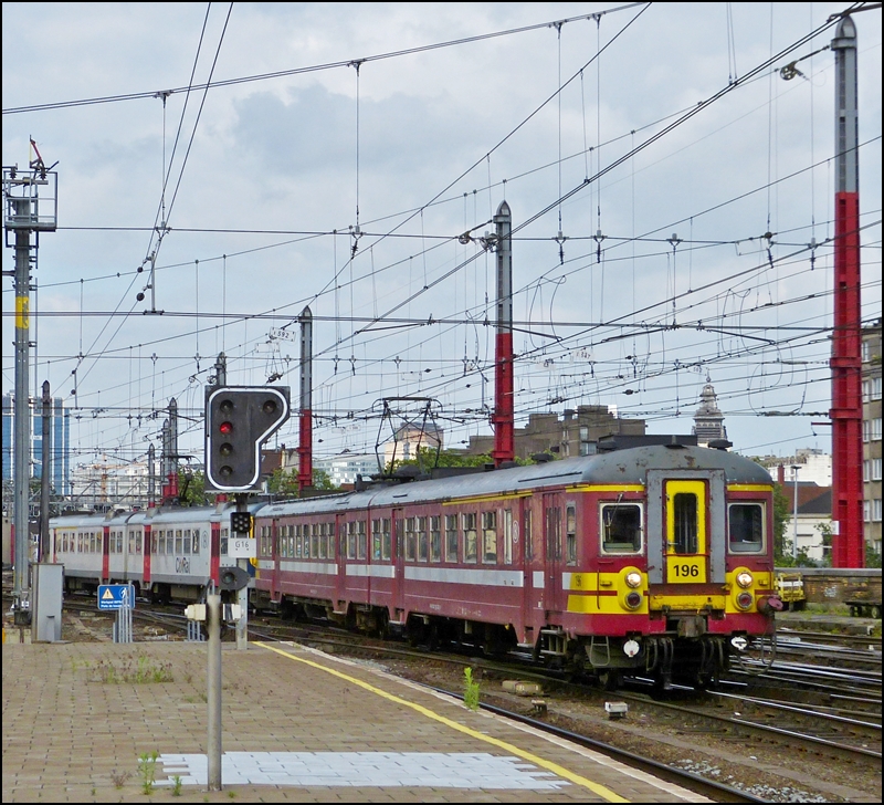 Die AM 62 196 (Baujahr 1962) erreicht unversprayt zusammen mit einer AM City Rail am 27.06.2012 den Bahnhof Bruxelles Midi. (Jeanny)

Die Abschiedsfahrt fr diese klassischen  Automotrices  soll am 23.03.2013 in Belgien stattfinden. So wie es momentan aussieht, werden diese schnen alten Fahrzeuge aber noch nicht in Rente geschickt, denn mit den neuen AM 08 (Desiro) gibt es soviele Probleme, dass die fr den Fahrpalnwechsel im Dezember 2012 geplante Inbetriebnahme bis jetzt nur auf einigen Strecken erfolgt ist. Der Lwenanteil des Regionalverkehrs wird noch immer von den scheinbar unverwstlichen AM 62 - 73 bestritten.   