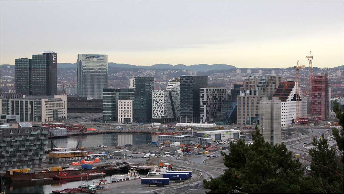 . Barcode-Areal in Oslo -

Ausblick vom Eckeberg unterhalb der Sjømannsskolen auf Oslo mit den Hochhäusern beim Bahnhof Oslo S und den ungewöhnlichen Architekturen des Barcode-Areals am Hafenbecken des Bjørvika. Die Autobahn, die vor diesen Neubauten und an der neuen Oper vorbeiführte wurde mittlerweile unter das Hafenbecken in einen Tunnel verlegt.

Dezember 2013 (Matthias)