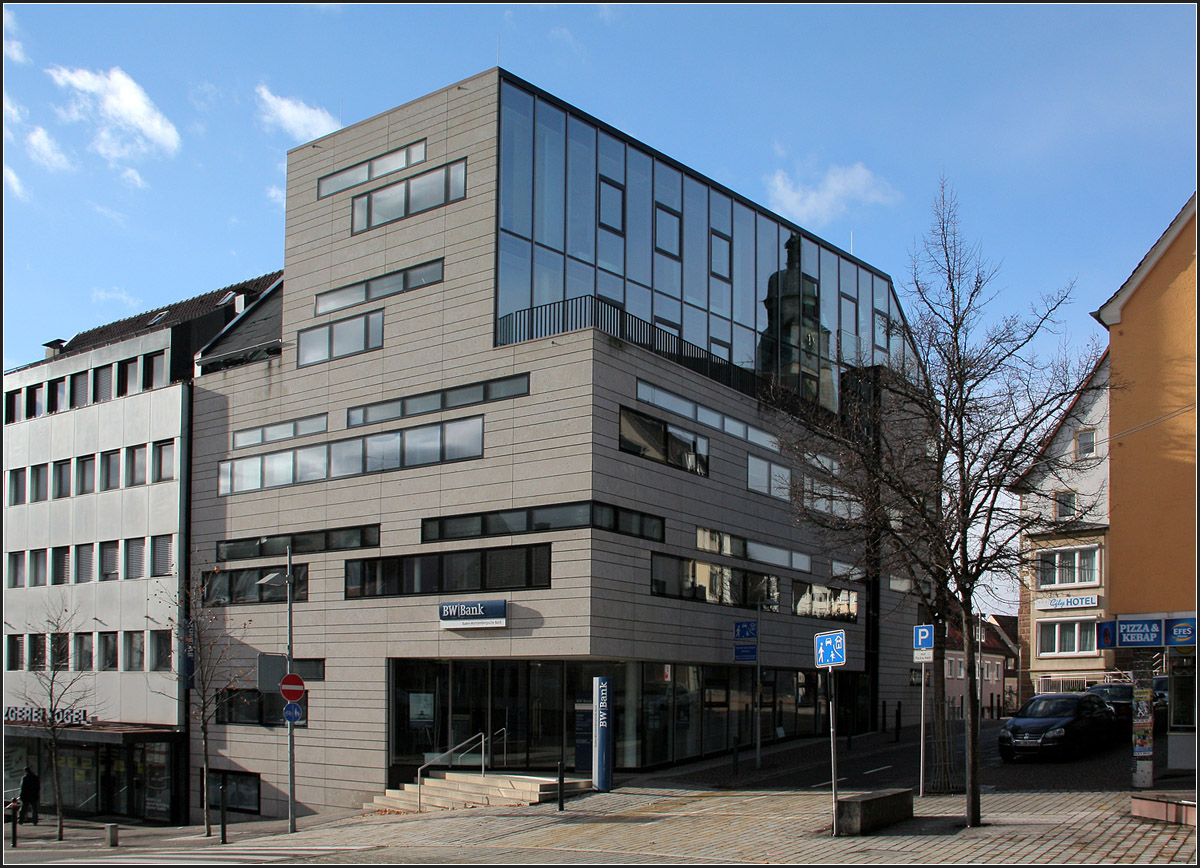 . Filiale der BW-Bank in Böblingen -

Aus einem Kubus wurden Teile ausgeschnitten um so den Anschluss an die Nachbarhäuser zu erreichen. Die Schnittflächen wurden verglast, während die anderen Fassaden mit einer Steinfassade versehen sind, unterbrochen von eigenartigen Fensterformen. Architekten: Kauffmann Theilg & Partner (Ostfildern), Fertigstellung: 2007

http://www.german-architects.com/de/ktp-architekten/projekte-3/filiale_der_bw_bank_boeblingen-43170

Dezember 2012 (Matthias)