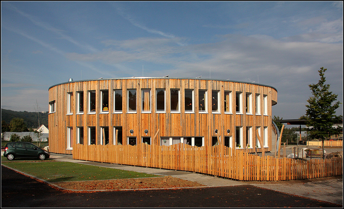 . Waldorfkindergarten in Esslingen am Neckar -

Neuer zweigeschossiger Waldorfkindergarten in Esslingen in der Pliensauvorstadt am westlichen Stadtrand.
Architekten Lederer, Ragnarsdóttir, Oei, Fertigstellung: 2013. Für die Fassade wurde Recycling-Holz verwendet.

In seinem städtebaulichen Umfeld (Niemandsland am Stadtrand), wirkt der ovale Bau als markanter Solitär, der sich bewusst von der Umgebung absetzt. Die Frage ist, ob es nicht besser gewesen wäre, die vorhandene Architektur der anschließenden Waldorfschule weiterzuführen und hier nicht noch mal was ganz anderes hier hin zu stellen. Das Gebäude ist schön, sein Umfeld ein Durcheinander.

http://www.archlro.de/de/projects/projects-health-and-education/neubau-waldorfkindergarten-esslingen?order=years

Oktober 2013 (Matthias)