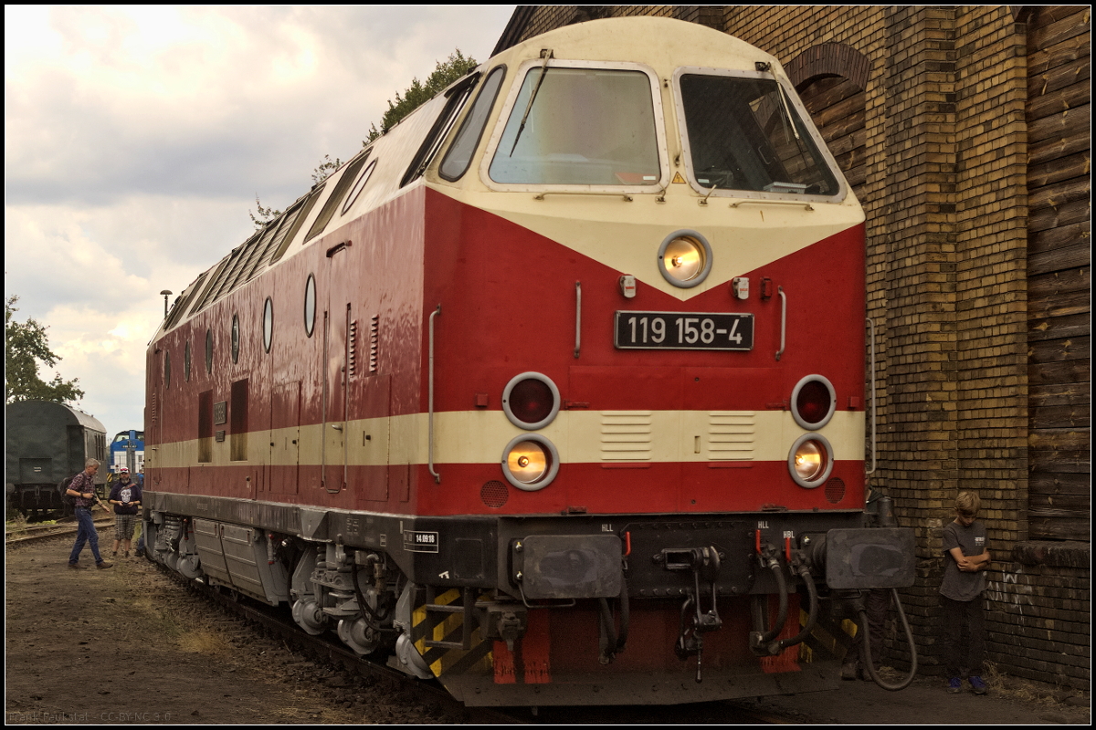 119 158-4 der Dampflokfreunde Berlin e.V. (DLFB) stand w�hrend des 15. Berliner Eisenbahnfest am 15.09.2018 an der Seite des Lokschuppens im Betriebsbahnhof Sch�neweide. Da es etwas eng wurde passte die Lok gerade so ins Bild. Wie gro� die Lok ist, sieht man im Vergleich zu dem jungen Besucher der gerade an der Lok vorbei ging (92 80 1219 158-3 D-DLFB).