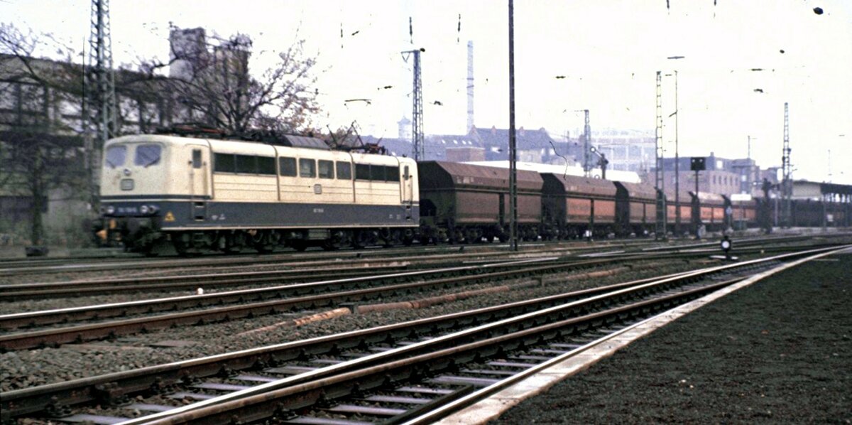 151 mit Mittelpufferkupplung und Erzwagen der Peine und Salzgitter AG in Lehrte am 27.11.1982.