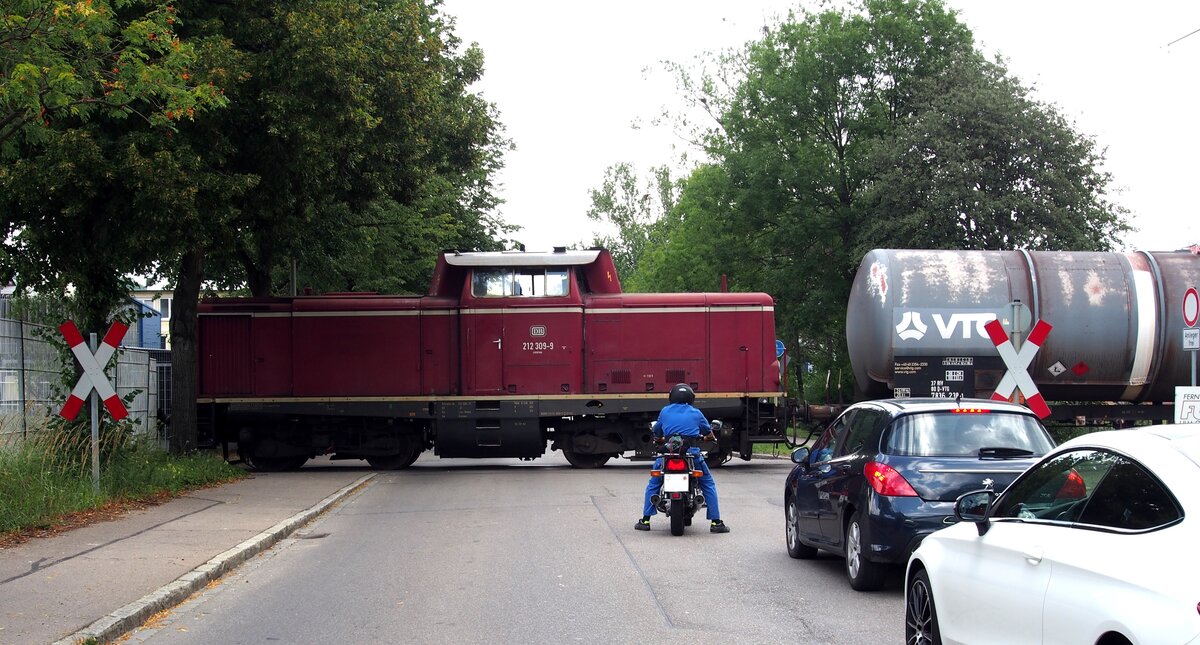 212 309-9 mit Kesselwagen über eine Straßenkreuzung im Industriegebiet in Ulm am 03.08.2019.