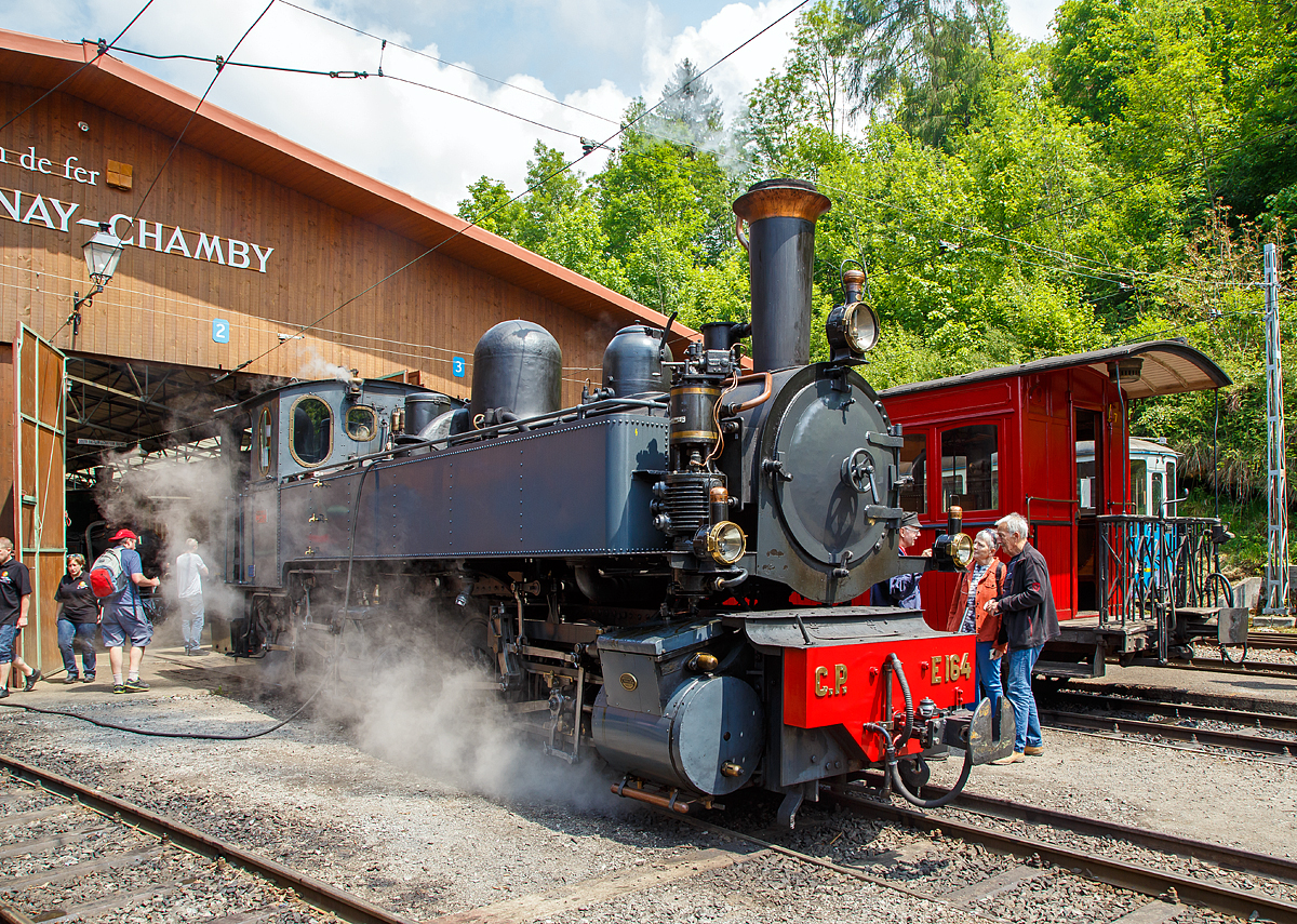 
50 Jahre BC - MEGA STEAM FESTIVAL der Museumsbahn Blonay–Chamby: 
Eine wahre Schöhnheit......
Die G 2x2/2 Mallet-Dampflokomotive ex C.P. E164, ex MD 404, vom Verein La Traction als Gastlok beim Mega Steam Festival der BC, hier am 19.05.2018 beim Depot in Chaulin.

Mallet-Dampflok wurde 1905 von Henschel in Kassel (damals noch Cassel) unter der Fabriknummer 7022 gebaut. Sie gehörte zu einer Serie von zehn Maschinen, die zwischen 1905 und 1908 von Henschel an die damalige Minho e Douro Bahn in Portugal geliefert wurde. Nach der Verstaatlichung im Jahre 1947 erhielt sie die Nummer C.P.  E168, so war sie bis 1978  im Einsatz. Der Verein La Traction hat sie1992 von der Caminhos de Ferro da Portugal (CP) gekauft. 1998 erhielt La Traction von der Fondation d'Impulsion économique régionale (FIER) einen Beitrag, um diese Lokomotive zu revidieren. Nach einer durchgreifenden Aufarbeitung durch das Dampflokwerk Meiningen in Deutschland kam diese Lokomotive im Sommer 1999 wieder in die Schweiz zurück. Sie wurde am 19. September desselben Jahrs eingeweiht. 
Es sei noch erwähnt, das Niederdruckfahrwerk stammt von der Lokomotive E 169, die heute in Vila Real aufgestellt ist.

Eine Schwesterlok die ex CP 168 ist in Brohl (Deutschland) siehe http://hellertal.startbilder.de/bild/Deutschland~Schmalspurbahnen~Brohltalbahn/433231/leider-ein-tristes-dasein-aber-ziel.html


TECHNISCHE DATEN:
Spurweite: 1.000 mm
Achsfolge: 	(B) B 
Länge über Kupplungen: 10.850 mm
Größte Höhe: 3.750 mm
Größte Breite: 2.700 mm
Gesamtachsstand: 5.200 mm
Triebraddurchmesser: 1.100 mm
Leergewicht: 34,5 t
Dienstgewicht: 42,0 t
Kohlenvorrat: 1,5 t
Wasservorrat: 5,5 m³
HD Zylinder: 2 x Ø 320 mm x 550 mm Hub
ND Zylinder: 2 x Ø 480 mm x 550 mm Hub	
Kesseldruck: 14 bar
Rostfläche: 1,33 m²
Höchstgeschwindigkeit: 40 km/h


Geschichte der Mallet-Lokomotiven:
Der zunehmende Verkehr auf schmalspurigen Eisenbahnen erschloss Mallet ein anderes Wirkungsfeld. Diese Bahnen benötigten stärkere und damit größere Maschinen, als es die engen Kurven der Schmalspurstrecken zuließen. Die einzige Lösung schienen hier Lokomotiven mit schwenkbaren Fahrwerken zu sein. Dazu waren bereits die Bauarten von Fairlie und Meyer verbreitet, die schwenkbare Maschineneinheiten verwendeten. Die einzelnen Einheiten wurden mit Dampf über flexible Verbindungen gespeist, die sich jedoch stets als Schwachpunkt der Maschinen erwiesen. Mallet entwickelte stattdessen eine Bauart mit zwei Fahrwerken, von denen nur das vordere, unter der Rauchkammer befindliche Fahrwerk schwenkbar gelagert war, während der Kessel fest auf dem anderen Fahrwerk ruhte. Damit reduzierte sich die Zahl der flexiblen Verbindungen um die Hälfte. Der wesentliche Unterschied der Konstruktion von Mallet im Vergleich zu den Bauarten Fairlie und Meyer war aber die perfekte Anwendung eines Verbundtriebwerkes. Der Frischdampf wird zunächst zu den Hochdruckzylindern des fest gelagerten Fahrwerks geleitet und nach dem Auslass in die Niederdruckzylinder des vorderen beweglichen Fahrwerks. Die dorthin führende bewegliche Dampfleitungsverbindung war wegen des geringeren Drucks besser beherrschbar als bei reiner Frischdampf-Versorgung. Diese Bauart ließ Mallet sich 1884 patentieren. 

Dampflokomotiven haben im Allgemeinen zwei Arbeitszylinder, die Mallet-Loks besitzen diese Einrichtungen doppelt, also 4 Zylinder mit zugehörigen Triebwerksgruppen. Der Abdampf der ersten ist gleichzeitig der Arbeitsdampf der zweiten Zylindergruppe.
