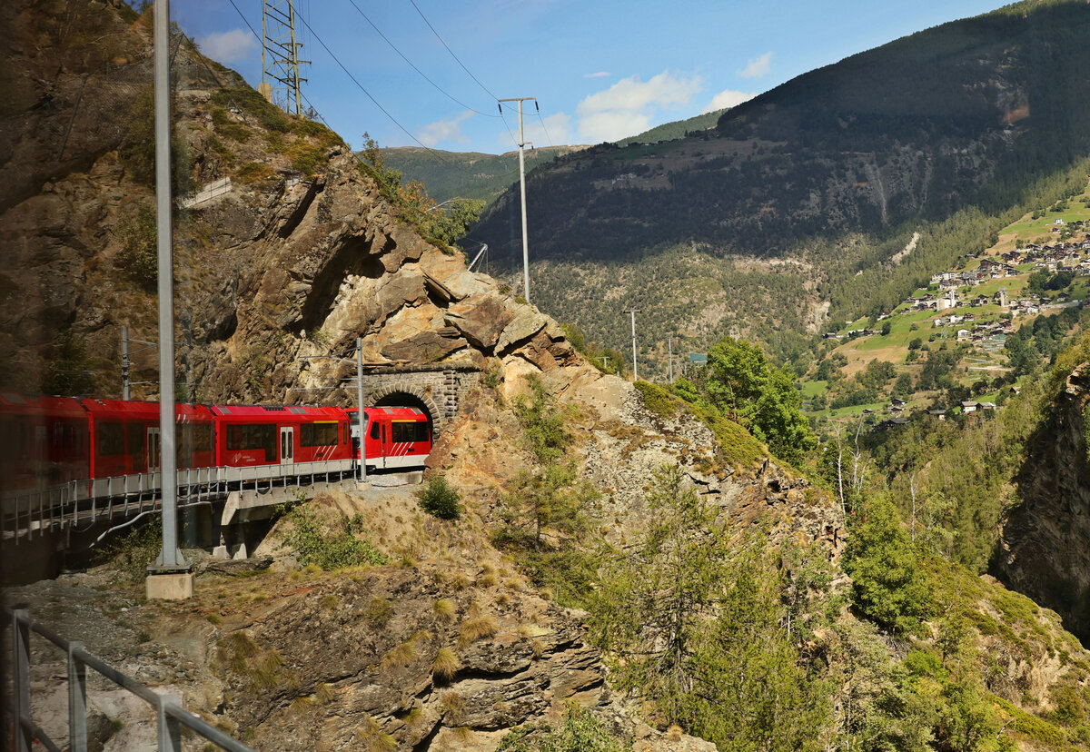 An der Matterhorn-Gotthard Bahn MGB: Im Abstieg nach Stalden durchfährt die Bahn einen wilden Steilhang hoch über der Schlucht; leider nur durch fixe Fenster photographierbar. Aus einem Zug mit 3  Orion . 30.August 2025 