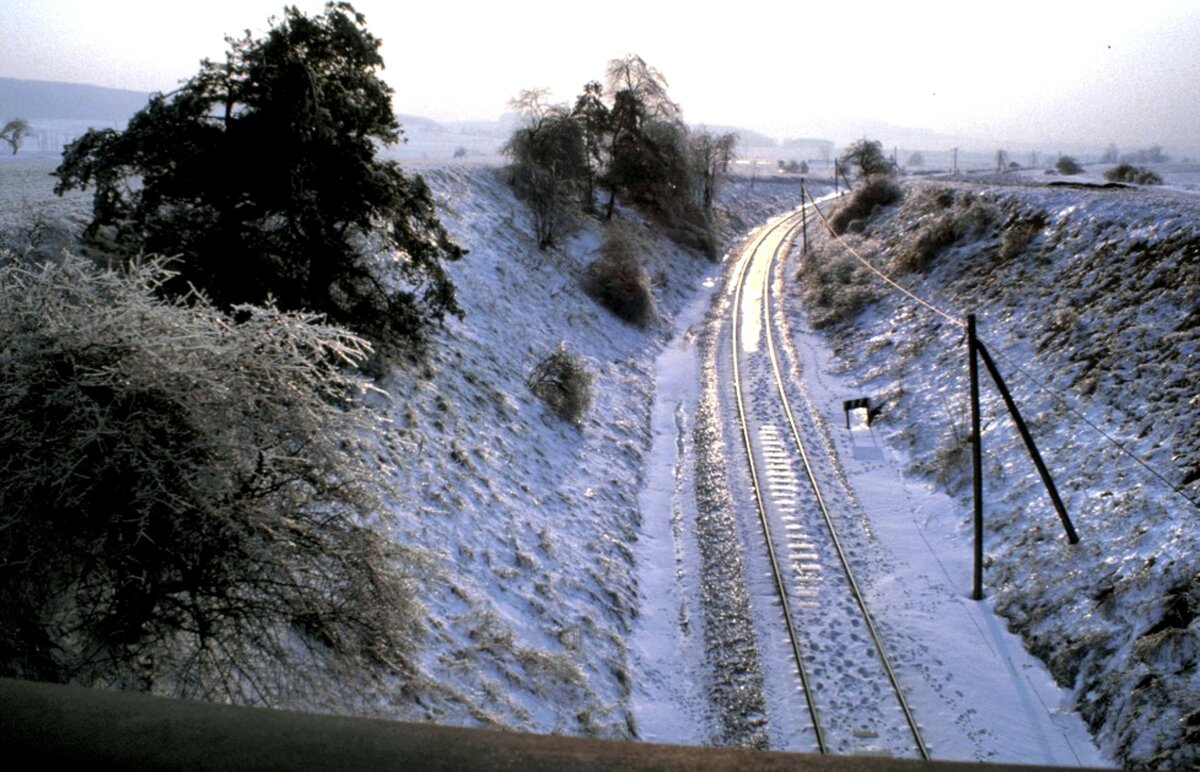 Aufgrund der heutigen Wintersituation, möchte ich die damals heftigere und länger anhaltende Situation zeigen: die Strecke der Hersfelder Kreisbahn bei Hatting am 09.03.1987. Die dünnen Grashalme sind mit eine relativ dicken Eisschicht überzogen.