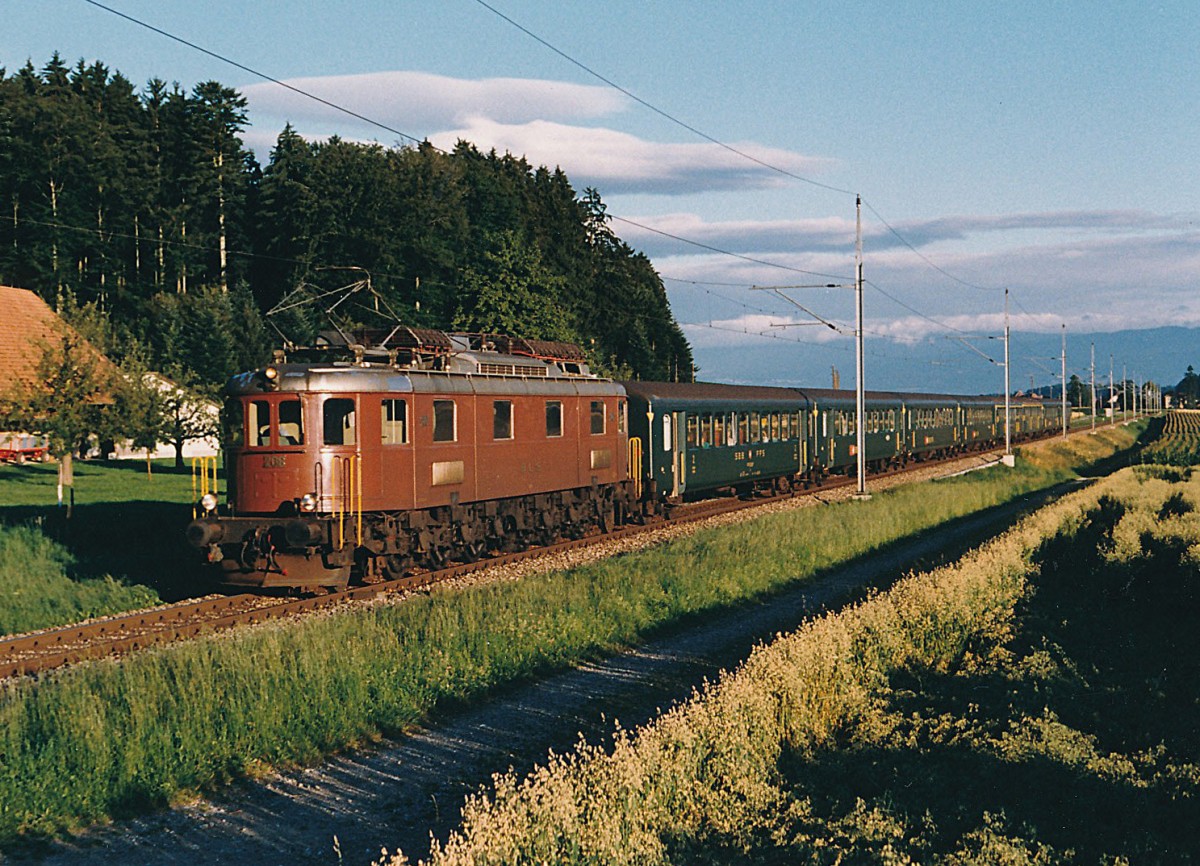 BLS/SBB: Morgenschnellzug Biel-Bern mit BLS Ae 6/8 208 und SBB EW ||-Wagen. Die Aufnahme ist in der Morgensonne zwischen Schüpfen und Münchenbuchsee im Juli 1986 entstanden.
Foto: Walter Ruetsch