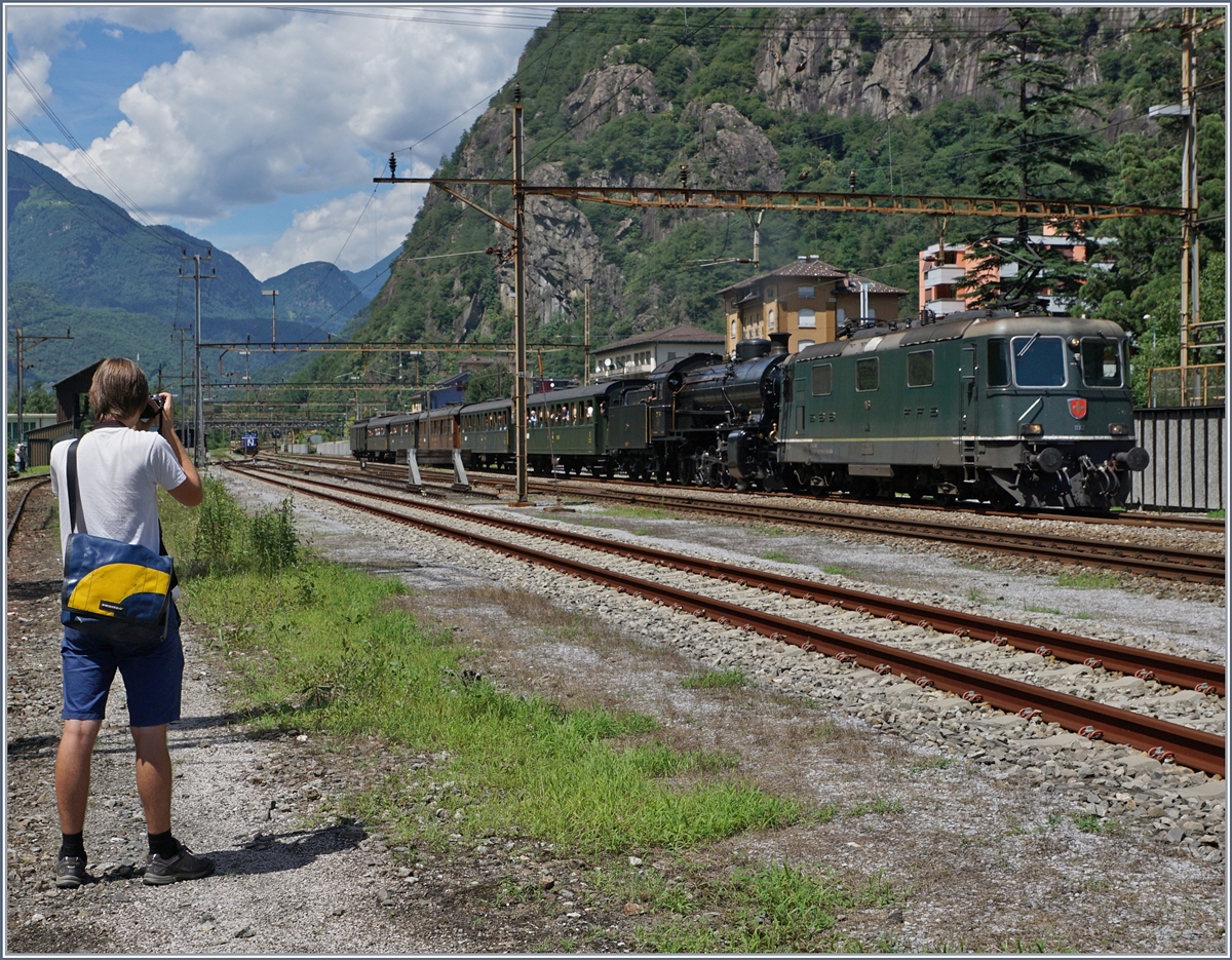 Da die Re 4/4 II 11161 über ETCS verfügt und grün ist, wird sie gerne als ETCS Vorspannlok bei historischen Zügen eingesetzt, so auch hier in Bodio wo die Lok dem Dampfzug für die Weiterfahrt nach Bellinzona vorgespannt wird. 
(Der (bekannte) Fotograf links im Bild habe ich absichtlich mit ins Bild genommen. 

28. Juli 2016