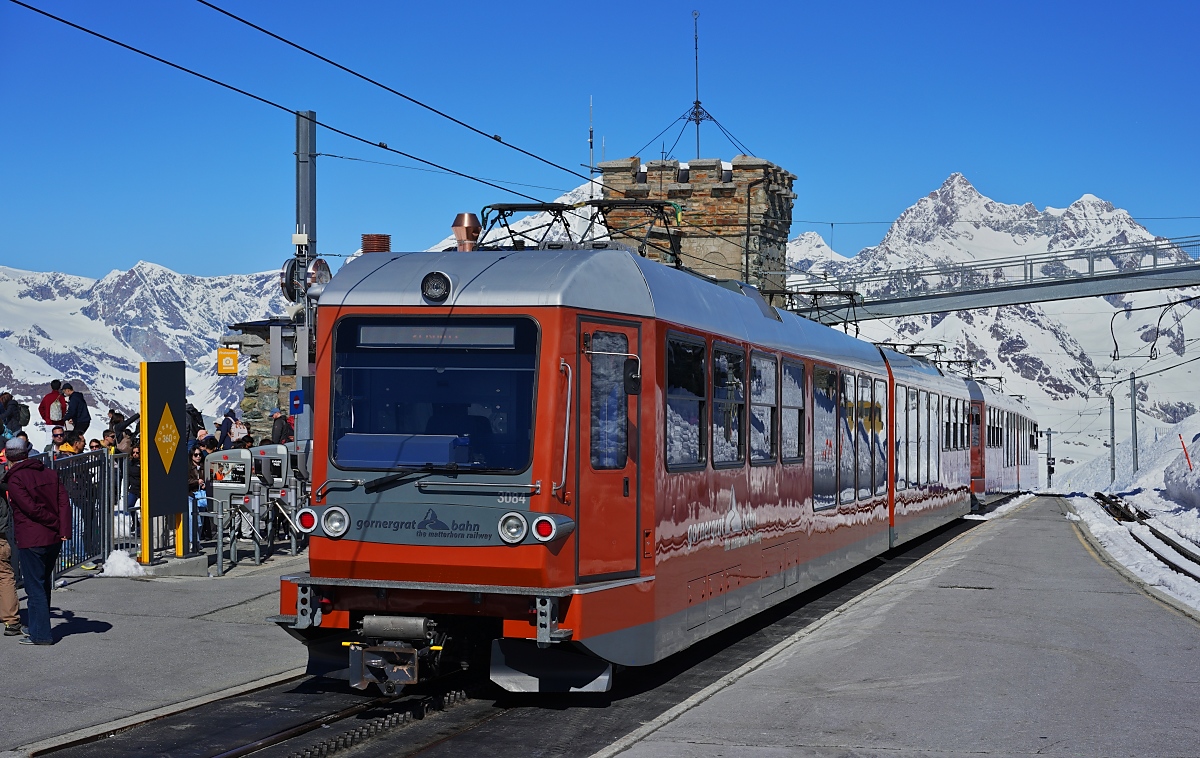 Der Gornergrat mal ohne Toblerone, dafr mit dem Dent Blanche: Am 10.05.2024 wartet ein Bhe 4/6-Doppel, vorne der Bhe 4/6 3084, auf Fahrgste nach Zermatt
