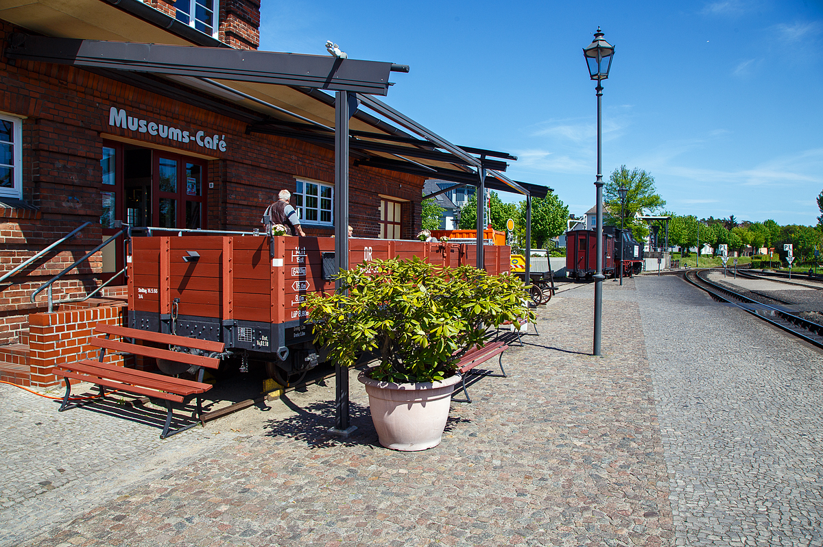 Der Terassenwagen, ein vierachsiger offener Güterwagen ex DR 98-02-55 der Gattung OOw, am Molli-Museums-Café beim Bahnhof Ostseebad Kühlungsborn-West (bis 1938 Ostseebad Arendsee) der Mecklenburgischen Bäderbahn Molli am 15.05.2022.

Der Wagen wurde 1911 von der Waggonfabrik Wismar für die DHE - Doberan-Heiligendammer-Eisenbahn (ab 1. April 1920 zur Deutschen Reichsbahn), gebaut. Von 2005 bis 2006 wurde er rekonstruiert und dient seit 2006 als Terassenwagen des Molli-Cafes.

TECHNISCHE DATEN:
Spurweite: 900 mm
Gattung: OOw
Anzahl der Achsen: 4
Länge über Puffer: 8.800 mm
Drehzapfenabstand: 5.000 mm
Achsabstand im Drehgestell: 1.300 mm
Länge der Ladefläche: 8.000 mm
Ladefläche: 16 m²
Eigengewicht: 6.400 kg
Tragfähigkeit: 14,3 t
