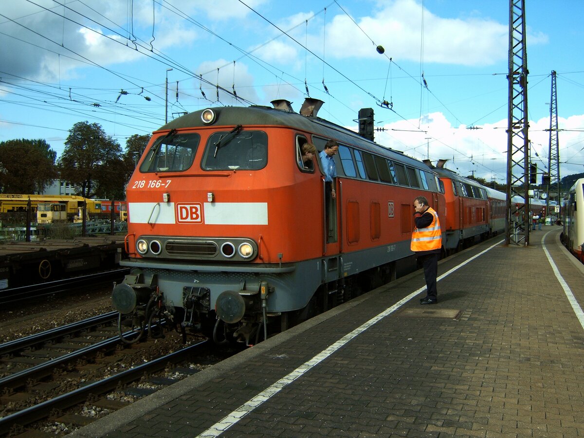 Der Zugführer geht mit seinem Handy zum Lokführer und läßt in Handy-Kontakt mit dem Stellwerk den Zug mit der 218 166-7 + 218 über das rote Signal vorziehen, bis der letzte Wagen die Weiche nicht mehr blockiert, aber auch vorn nicht im Profilbereich der anderen Gleise steht. Ulm am 17.08.2005.