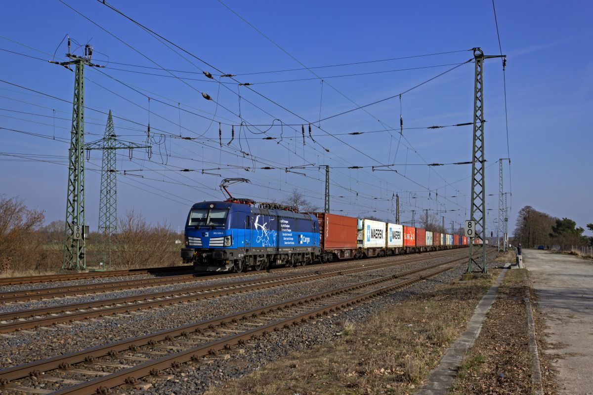 Die 383 020 wirbt auf ihren Seitenfl�chen mehrsprachig mit der Einsetzbarkeit  Quer durch Europa . Immerhin ist die Lok in insgesamt acht L�ndern von den Niederlanden bis nach Ungarn einsetzbar, unter anderem auch in Deutschland, sodass sie hier in Saarmund ihren Containerzug in Richtung Westen bef�rdern kann.