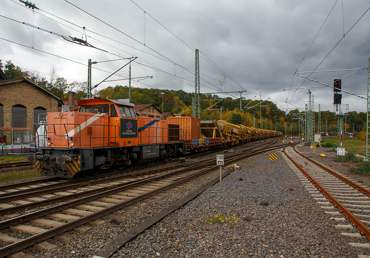 Die an die BEG - Bocholter Eisenbahngesellschaft mbH vermietete 275 103-0 (92 80 1275 103-0 D-NRAIL) eine Vossloh G 1206 der Northrail fährt am 22.10.2021 mit einem langen Bauzug der MGW Gleis- und Weichenbau-GmbH & Co. KG (Berlin) durch Betzdorf (Sieg) in Richtung Siegen. Der Bauzug bestand aus acht Plasser & Theurer Materialförder- und Siloeinheit MFS 100, der Plasser & Theurer Bettungsreinigungsmaschine RM 95-700, sowie zwei Schutzwagen.

Die G 1206 wurde 2001 von Vossloh unter der Fabriknummer 1001139 gebaut und war erst als Vossloh Mietlok im Einsatz. Im Jahr 2006 ging sie an die Mittelweserbahn GmbH in Bruchhausen-Vilsen als MWB V 2103 (ab 2007 NVR-Nummer: 92 80 1275 103-0 D-MWB). 2013 wurde sie an die Vermietungsfirma Northrail GmbH in Hamburg verkauft. 

TECHNISCHE DATEN der G 1206:
Spurweite: 1.435 mm
Antriebart:  dieselhydraulisch
Achsfolge: B'B' 
Länge über Puffer: 14.700 mm
Drehzapfenabstand: 7.200 mm
Achsabstand im Drehgestell: 2.400 mm
größte Breite: 3.080 mm
Höhe über Schienenoberkante: 4.220 mm
Raddurchmesser neu: 1.000 mm
Motor: Caterpillar 12 Zylinder 4-Takt Dieselmotor mit Abgasturbolader und Ladeluftkühlung vom Typ 3512B DITA-SC
Leistung: 1.500 kW bei1.800 U/min
Strömungsgetriebe: Voith L5r4zU2 
Anfahrzugkraft: 282 kN
Höchstgeschwindigkeit 100 km/h
max. Schleppgeschwindigkeit : 80 km/h
kleinste Dauerfahrgeschwindigkeit: 10 km/h
kleinster befahrbarer Gleisbogen: 60 m
Dienstgewicht: 87,3 t
Kraftstoffvorrat: 3.150 l
Zulassungen: DE, NL, FR, CH