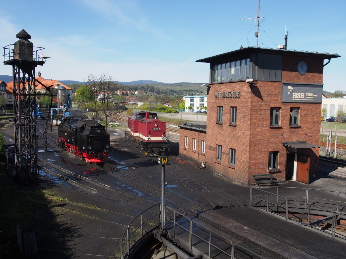 Die HSB hat einen besonders guten Service eingerichtet mit der Aussichtsplattform auf einem alten Schuppen. Der Blick über das Bw-Areal, wie auch den Bahnsteiggleisen ist sehr gut möglich. Hier ist die fertig vorbereitete 99 7234-0 und die abgestellte 199 874-9 mit Besandungsanlage und Stellwerk und einem Teil der Drehscheibe zu sehen. Der nahezu klare Blick zum Brocken ist möglich. Die zum Fotozeitpunkt aktuelle Temperatur auf dem Brocken war +0,7°C mit ca. 2  cm Neuschnee.Bw Werningerode am 29.04.2015.