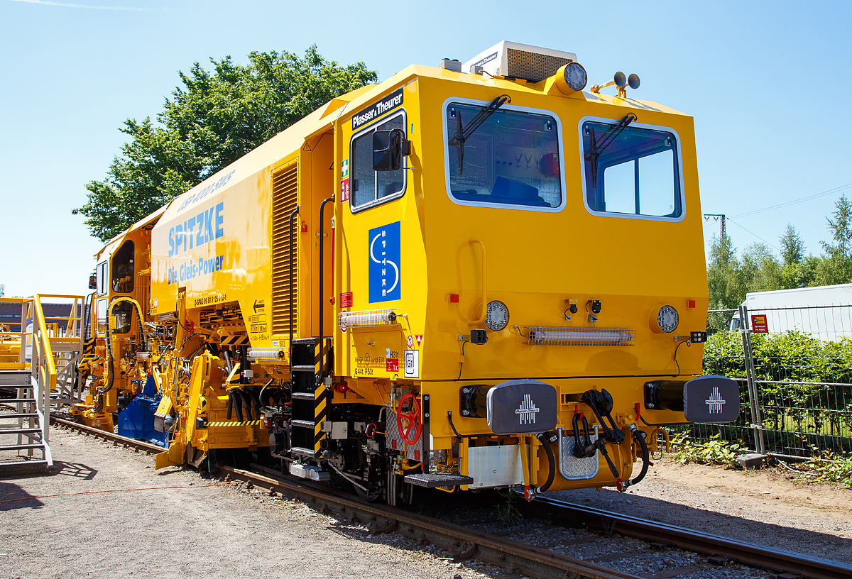 
Die neue Plasser & Theurer Schotterverteil- und Planiermaschine USP 4000 SWS, Schweres Nebenfahrzeug-Nr. D-SPAG 99 80 91 25 012-1, der SPITZKE SE, präsentiert auf der iaf 2017 in Münster (hier am 01.06.2017).

Die USP 4000 SWS wurde 2017 von Plasser & Theurer in Linz (A) unter der Maschinen Nr. 6723 gebaut.

Die Schotterverteil- und Planiermaschine USP 4000 SWS stellt das perfekte Schotterbett von Gleisen und Weichen in nur einem Arbeitsdurchgang her. Das „One-Pass-Verfahren“ soll die Verteilung und Planierung des Schotters in einem Arbeitsgang ermöglichen. Die neue Anordnung der Aggregate ermöglicht, dass der aufgekehrte Schotter direkt vor die Arbeitsorgane oder durch die vier Entladeöffnungen des Bodenförderbands an jeder gewünschten Stelle im Bereich der Stopfzonen ausgegeben werden kann.

In der „Technischen Spezifikation für die Interoperabilität zum Teilsystem Fahrzeuge – Lärm“ (TSI Noise 2015) wurden für neue Schienenfahrzeuge europaweit einheitliche Grenzwerte festgelegt. Die Schotterverteil- und Planiermaschine USP 4000 SWS gehört zu den ersten Maschinen, die diese Vorgaben erfüllt, und markiert deshalb einen neuen Standard. 

Bei der USP 4000 SWS sind alle Aggregate so angeordnet, dass technologisch richtiges Arbeiten möglich ist und die Verteilung und Planierung des Schotters in einem Arbeitsgang erfolgen kann. Durch das Bodenförderband und die Verteilschächte im vorderen Teil der Maschine kann sie auch für punktuelle Einschotterungen eingesetzt werden. 

Entscheidend bei allen Einsätzen ist das neue Design mit zwei Kabinen, das uneingeschränkte UIC-Sicht in beide Fahrtrichtungen gewährleistet. Bei Überstellfahrten lässt sich die USP 4000 SWS nun wie das Schotterbewirtschaftungssystem BDS vorwärts- und rückwärtsfahren. 

Besonderes Augenmerk wurde bei der Konstruktion auf den Schutz vor Lärm und Staub gelegt. So erhielt die Kehranlage für Gleise und Weichen eine spezielle Gummiauskleidung, die sowohl den Lärm als auch den Verschleiß reduziert. Das Schottersilo mit einem Fassungsvermögen von 5 m³ ist mit ROBALON-Kunststoffplatten ausgekleidet. Eine Staubniedernebelungsanlage reduziert die Staubemissionen im gesamten Arbeitsumfeld.
Bei leerem Silo erfüllt die Maschine auch die Anforderungen der Streckenklasse C2. Im Rahmen der iaf 2017 wurde diese neue USP 4000 SWS der Firma Spitzke übergeben, als topaktuelle Ergänzung für die leistungsfähige Instandhaltungsflotte.  

TECHNISCHE DATEN:
Spurweite: 1.435 mm
Achsanzahl: 4
Länge über Puffer: 19.140 mm
Drehzapfenabstand: 11.500 mm
Achsabstand im Drehgestell: 1.800 mm
Eigengewicht: 64 t
Motorleistung: 470 kW
Max. Geschwindigkeit geschleppt:  90 km/h
Max. Geschwindigkeit Eigenantrieb: 100 km/h
Min. Kurvenradius: 120 m

Leistungsparameter:
Arbeitsleistung bei Durcharbeitung des Gleises: max. 1.800 m/h
Arbeitsleistung bei Umbau des Gleises: max. 1.400 m/h
Arbeitsradius: ≥ 150 m
Arbeiten in Überhöhung: max. 180 mm