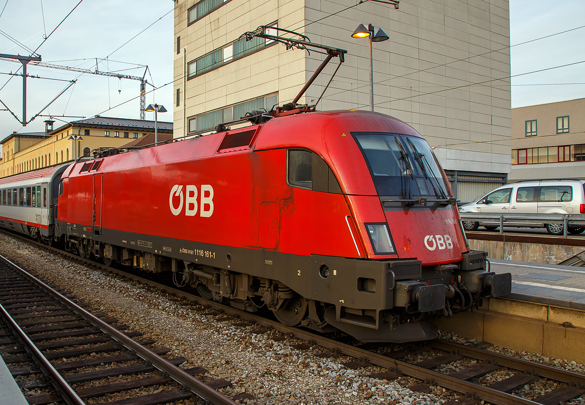 
Die ÖBB 1116 161 (A-ÖBB 91 81 1116 161-1) als Schublok des EC 112 „Blauer Enzian“ am 08.02.2020 beim Halt im Hauptbahnhof Augsburg.

Die ÖBB Taurus II eine elektrische Universallokomotive vom Typ Siemens ES64U2 wurde 2003 von Siemens in München unter der Fabriknummer 20882 und als 1116 161-9 an die ÖBB geliefert.

Die ES 64 U2 wurde ursprünglich als Universallok für die Österreichischen Bundesbahnen (ÖBB) entwickelt und wird dort als Baureihe 1016 (reine 15-kV-Version) und 1116 (2-System-Version mit 15 kV und 25 kV für internationalen Verkehr) geführt. Die Zweisystembauart für 15 kV- und 25 kV-Bahnstromsysteme ist traktions- und sicherungstechnisch für Deutschland, Österreich und Ungarn ausgerüstet und zugelassen, seit Mai 2002 ist zudem ihr Einsatz teilweise in der Schweiz erlaubt. Durch die vorhandene Technik ist sie ebenso für die Wechselstromstrecken in Tschechien und der Slowakei geeignet. Die Maschinen der Serie ES 64 U2 sind wendezugfähig ausgeführt und ab Werk mit zwei Einholm-Stromabnehmern ausgerüstet. Ausnahme sind die Railjet-Loks 1116.201 bis 1116.223, welche mit den in die Schweiz verbundenen Fahrten, einen dritten (schmaler) Stromabnehmer haben. Der Antrieb der Lok erfolgt über einen speziell für sie entwickelten Hohlwellen-Antrieb mit Bremswelle (HAB).

Die Lok der Reihe 1016 und 1116 sind auch oft hörbar zuerkennen: Beim Aufschalten aus dem Leerlauf ist ein Geräusch zu vernehmen, das an das Durchspielen einer Tonleiter auf einem Tenorsaxophon erinnert. Es entsteht in den Drehstrommotoren durch die Ansteuerung der Stromrichter. Das hörbare Geräusch ist dabei die doppelte Taktfrequenz der Pulswechselrichter, welche stufenweise angehoben wird.

Die Frequenz ändert sich dabei in Ganz- und Halbtonschritten über zwei Oktaven von d bis d  im Tonvorrat der Stammtöne.

TECHNISCHE DATEN:
Spurweite: 1.435 mm (Normalspur)
Achsformel: Bo’Bo’
Länge über Puffer: 19.280 mm
Höhe: 4.375 mm
Breite: 3.000 mm
Drehzapfenabstand: 9.900 mm
Achsabstand in Drehgestell: 3.000 mm
Kleinster bef. Halbmesser: 100 m (bei 10 km/h) /120 m (bei 30 km/h)
Dienstgewicht: 88 t
Max. Achslast: 22 t
Höchstgeschwindigkeit: 230 km/h
Dauerleistung: 6.400 kW
Max. Leistung (Booster für 5 min): 7.000 kW (nur bei 85–200 km/h nützlich)
Anfahrzugkraft: 300 kN
Dauerzugkraft: 250 kN (bis 92 km/h)
Raddurchmesser: 1.150 mm (neu) / 1.070 mm (abgenutzt)
Motorentyp: 1 TB 2824-0GC02
Stromsystem: 15 kV, 16,7 Hz und 25 kV, 50 Hz
Anzahl der Fahrmotoren: 4
Antrieb: GTO Stromrichter und Hohlwellen-Drehstrom Fahrmotoren
Dynamisches Bremssystem: Elektrodynamische Hochleistungs-Rückspeisebremse
Nenn- / Höchstleistung der dynamischen Bremse: 6.400 kW / 7.000 kW (mit Booster)
Max. Bremskraft der dynamischen Bremse: 240 kN
