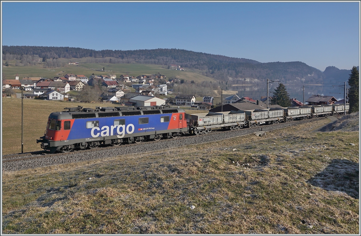 Die SBB Re 6/6 11610 (Re 620 010-9)  Spreitenbach  bringt etliche leere Fans-u Wagen als Güterzug 69701 von Lausanne-Triage nach Le Brassus und konnte hier bei Les Charbonnières mit dem Hintergrund des Lac de Brenet fotografiert werden. 

24. März 2022