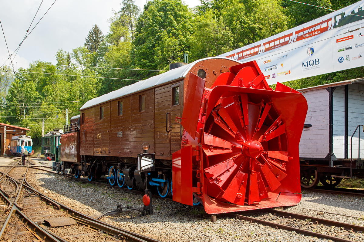 Die Selbstfahrende Dampfschneeschleuder R 1052 (ex (Berninabahn) BB R 1052, ex RhB R 14, ex RhB Xrot d 9214), der Museumsbahn Blonay-Chamby,hier am 19.05.2018 auf dem Museums-Areal der (BC) in Chaulin.

Die Schneeschleuder wurde 1912 von der Schweizerischen Lokomotiv- und Maschinenfabrik (SLM) unter der Fabriknummer 2299 als R 1052 für die Berninabahn gebaut, 1944 um bezeichnet in RhB R 14, 1954 um nummeriert in RhB Xrot d 9214 (Die Bezeichnung Xrot d setzt sich zusammen aus: X = Dienstfahrzeug, rot = rotierend, d = dampfgetrieben.), 1990 ging sie an die DFB, 1996 wurde sie  im Tausch gegen die ehemalige RhB R 12 von der B-C übernommen.

Dieses Fahrzeug wie auch das heute noch bei der RhB betriebsfähige Schwesterfahrzeug Xrot d 9213 (ex BB R 1051) sind dampfgetriebene Schneeschleudern mit eigenem Antrieb die für die Berninabahn (BB) gebaut wurden, die seit 1944 zur Rhätischen Bahn gehört. Im Gegensatz zu den bisher gebauten Fahrzeugen, auch der zwei Dampfschleudern der RhB-Stammstrecke, handelt es sich bei den beiden Bernina-Schleudern um selbstfahrende Fahrzeuge. Die Berninabahn entschied sich hierzu, weil in den engen Kurven mit nicht genügend hoher Kraft geschoben werden konnte und die Bahn selbst keine Fahrdraht-unabhängigen Triebfahrzeuge besaß. Die Schleudern wurden dennoch normalerweise mit Schiebetriebfahrzeugen eingesetzt, damit die gesamte Kesselleistung für die Dampfmaschine des Schleuderrades zur Verfügung stand.

Mit der Übernahme der Berninabahn durch die Rhätische Bahn (RhB) erhielten die beiden Schleudern die neuen Bezeichnungen R 13 und R 14, 1950 dann Xrot d 9213 und 9214. Die beiden Fahrzeuge befanden sich bis 1967 im regelmäßigen Einsatz und wurden danach durch modernere Schleudern ersetzt. Die Xrot d 9213 wird von der RhB im Heimatdepot in Pontresina weiterhin betriebsfähig gehalten. Sie wird heute vor allem zu touristischen Zwecken noch betrieben, und zwar im Rahmen so genannter Fotofahrten; zuweilen kommt sie aber auch noch bei der Räumung zum Einsatz.

Die Achsformel ist C'C', das Fahrzeug verfügen nach Bauart Meyer über zwei dreiachsige Triebdrehgestelle die durch vier Zylinder angetrieben werden, diese befinden sich unten mittig zwischen den Triebgestellen, darüber befindet sich der Antrieb für die Schneeschleuder, die von zwei weiteren Zylindern angetrieben wird. Der Durchmesser des Schleuderrads beträgt 2,5m, welches mit bis zu 170 U/min dreht und so bis zu drei Meter hohe Schneemassen beseitigen kann.
Gekuppelt ist die Schneeschleuder mit einem zweiachsigen Tender.

Die Xrot d 9214 wurde am 26. Januar 1968 zu einem einmaligen Großeinsatz auf der Arosabahn herangezogen. Geschoben von zwei ABDe 4/4 hatte sie die tiefverschneite Strecke zwischen Langwies und Arosa zu räumen und benötigte für den nur acht Kilometer langen Abschnitt acht Stunden.

TECHNISCHE DATEN:
Gebaute Anzahl: 2 (BB 1051, BB 1052)
Hersteller:  SLM
Baujahre:  1910 und 1912
Ausmusterung:  1967 (1052/ 9214), Die 1051 ist als RhB Xrot d 9213 betriebsfähig
Spurweite:  1.000 mm (Meterspur)
Achsformel: C'C'
Länge: 13.865 mm
Höhe: 3.800 mm
Breite: 2.800 mm, max. 3.600 mm
Gesamtradstand: 10.655 mm (inkl. Tender)
Kleinster befahrbarer Gleisbogen: R=45 m
Dienstgewicht: 45 t
Dienstgewicht mit Tender: 63,5 t
Höchstgeschwindigkeit:  35 km/h
Indizierte Leistung Antrieb: 221 kW
Indizierte Leistung Schneeschleuder: 368 kW
Treibraddurchmesser:  750 mm
Zylinderanzahl: 4 für Antrieb und 2 für Schneeschleuder
Kesselüberdruck: 14 bar
Wasservorrat:  7 m³
Kohlevorrat:  4 t 