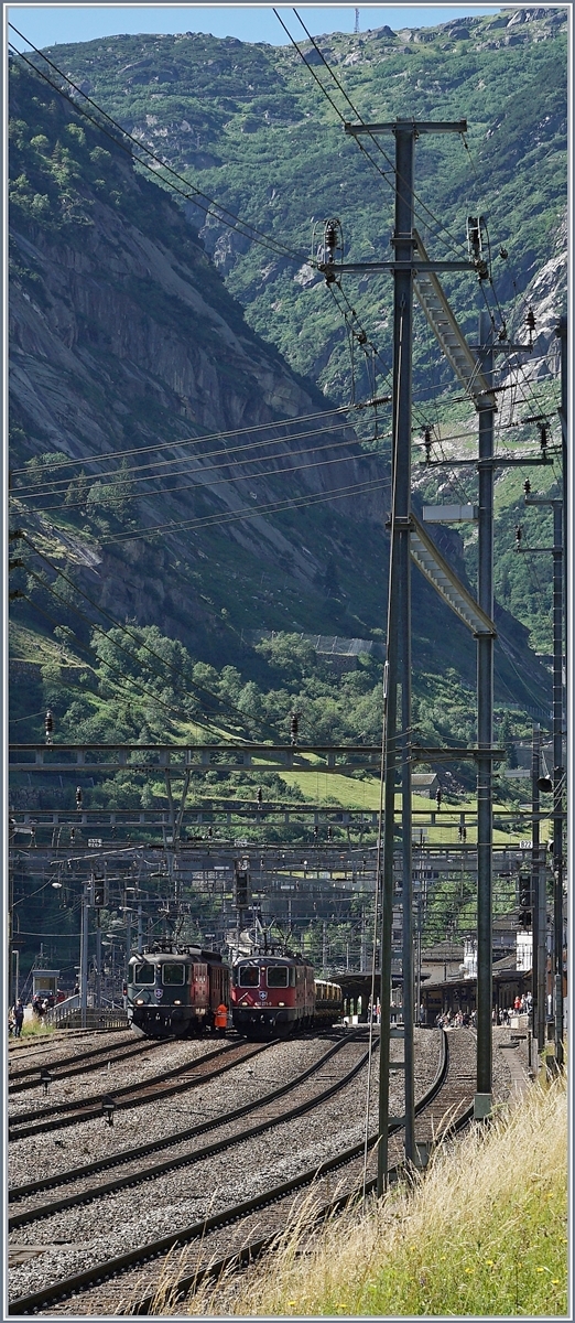 Ein etwas gewagter Schnitt mit Blick auf die nach Andermatt aufsteigende Schöllen-Schlucht und die im Bahnhof von Göschenen zu sehenden Re 4/4 II in Grün und Rot.
Während die beiden Roten Re 4/4 II mit einem Güterzug Richtung Erstfeld unterwegs sind, begleitet die grüne SBB Re 4/4 II 11161 den SF-Dampfzug über von Erstfeld nach Bellinzona (und zurück).
28. Juli 2016