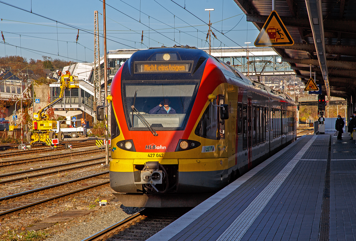 Ein FLIRT im Licht und Schatten....
Der 3-teilige Stadler FLIRT 427 042 / 827 042 / 427 542 (94 80 0427 124-3 D-HEB / 94 80 0827 124-9 D-HEB / 94 80 0427 624-2 D-HEB) der HLB Bahn (Hessischen Landesbahn) hat am 12.11.2021, als RE 99 Gießen – Siegen (Umlauf HLB 24936), den Hauptbahnhof Siegen erreicht.

Der Triebzug wurde 2010 von Stadler Pankow in Berlin unter den Fabriknummern 38623/38624, 38623/38626 und 38623/38625 gebaut und an die HLB geliefert.

Die Bezeichnung „FLIRT“ steht für „Flinker Leichter Innovativer Regional Triebzug“. Seit Dezember 2010 sind für die HLB die dreiteiligen (Baureihe 427) und fünfteiligen (Baureihe 429) elektrischen Niederflurtriebzüge des Typs FLIRT der Firma Stadler Pankow GmbH im „Main-Lahn-Sieg-Netz“ im Einsatz. Die Triebzüge entsprechen höchsten Komfortansprüchen und sind in Aluminium-Leichtbauweise gebaut.

Technische Daten:
Spurweite: 1.435 mm (Normalspur)
Achsformel: Bo'2'2' Bo'
Länge über Scharfenberg-Kupplung: 58.178 mm
Breite:  2.880 mm
Höhe: 4.185 mm
Achsabstände im Drehgestell: 2.700 mm
Triebraddurchmesser: 870/800 mm (neu/abgenutzt)
Laufraddurchmesser: 750/690 mm (neu/abgenutzt)
Dauerleistung am Rad: 1.500 kW
Max. Leistung am Rad: 1.950 kW
Anfahrzugkraft baulich (bis 55 km/h): 150 kN
Max. Beschleunigung bis 80 km/h: 1,01 m/s²
Höchstgeschwindigkeit: 160 km/h
Leergewicht: 100 t
Speisespannung: 15 kV, 16 1/3 Hz
Sitzplätze: 16 (1. Kl.) / 116 (2. Kl.) / 48 Klappsitze