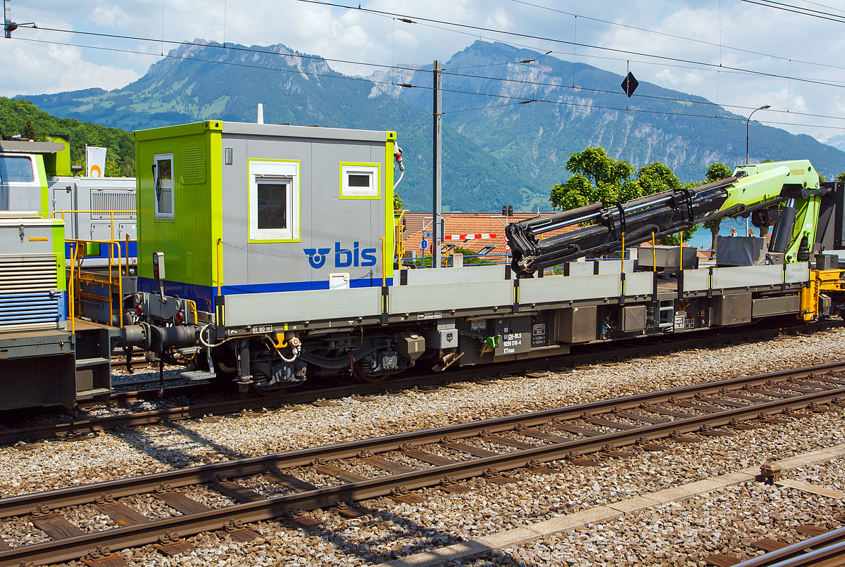 
Erhaltungsfahrzeug EHF bzw. der selbstfahrende Dienstwagen XTmas 516 mit Palfinger Kran 100002 D 100mt  (99 85 92 59 516-4 CH-BLS) abgestellt am 28.05.2012 beim Bahnhof Spiez (aufgenommen aus einfahrendem Zug).

Für die Durchführung der Arbeiten innerhalb der Erhaltungsabschnitte werden Erhaltungsfahrzeuge (EHF)  mit modularen, den jeweiligen Anforderungen entsprechenden, Aufbauten und Ausrüstungen eingesetzt.
Im Laufe des Jahres 2006 erhielt die BLS insgesamt 13 Erhaltungsfahrzeuge von der Firma SCHÖRLING-BROCK GmbH in Gehrden bei Hannover. Von den13 Fahrzeugen besitzen 9 einen hydrostatischen Antrieb, der den Eigenbetrieb bis zu einer Geschwindigkeit von 60 km/h erlaubt, der geschleppte Betrieb ist bis 100 km/h zugelassen. Die UIC-Konformität der Konstruktion ist gegeben. Die Fahrzeuge sind im Konzept eines 60“-Containerwagens gestaltet mit unterschiedlichen Aufbauten und einem Leergewicht zwischen 21 t für einen nicht angetriebenen und 47 t für diesen angetriebenen Tragwagen mit aufgebautem 100mt-Kran und 14 Tonnen Gegengewicht. Bei dem einheitlichen Gesamtgewicht aller Wagen von 72 t ergeben sich somit für Baufahrzeuge beachtliche Zuladungskapazitäten.

Die geringe Ladehöhe von 1.140 mm sowie die maximale Pufferhöhe von 990 mm ergeben mit der damit einhergehenden Überlademöglichkeit für Langgut vielseitige Anwendungsmöglichkeiten.
Die Bremsanlage wird generell mit einer Federspeicherbremse ergänzt. Bei den angetriebenen Fahrzeugen ist neben der Lokbremse auch noch eine Anhängerbremse vorhanden.

Technische Daten Grundfahrzeug mit Antrieb:
Angetrieben werden jeweils die inneren Achsen der Drehgestelle mittels Hydrostat und Getriebe von einem 210 kW starken Deutz-Motor mit Partikelfilter der Fa. Hug Engeneering AG.
Der Energiebedarf der Aufbauten oder von Werkzeugen neben dem Fahrzeug wird von einem hydrostatisch angesteuerten Generator mit 50 bzw. 60 kVA gewährleistet. Um eine möglichst tief liegende Ladefläche verwirklichen zu können, kommen vom UIC-Standarddrehgestell Y31 abgeleitete Drehgestelle der Bauart Y31Lssif-D-(AK) von der Firma Eisenbahn Laufwerke Halle (ELH) zum Einsatz, welche sich bei einem Neuraddurchmesser von 760mm durch eine tief liegende Abstützebene für das Untergestell auszeichnen
Für Start, Beleuchtung und Gewährleistung von Notfunktionen über eine EPumpe stehen 24 V/630 Ah Batteriekapazität zur Verfügung.
Als Steuerungselektronik kommen fahrzeugtaugliche Digsy Outdoor-Komponenten der Firma Intercontrol mit einer Funkfernsteuerung der Firma Theimeg zum Einsatz. Diese Kombination ist bereits auf Baudienstfahrzeugen der Deutschen Bahn AG im Einsatz.
Neben den Kranaufbauten werden variabel aufsetzbare Aufbauten wie Kabelrollböcke, Arbeitsbühnen sowie Mannschafts- und Magazincontainer mit 10 Fuß und 20 Fuß Länge eingesetzt.
Fixe und abnehmbare Aufbauten sind als Mannschaftsraum und WC ausgebildet.
Zum Einsatz der Funkfernbedienung mit V-Max 80 km/h sind diese mit Notbremsventil ausgeführt. Die Steuerung der Erhaltungsfahrzeuge erfolgt im Fahrbetrieb generell mit einer Theimeg-Funkfernsteuerung. Im Kranbetrieb erfolgt die Versetzfahrt mit bis zu 9,5 km/h über die Kranfernbedienung. Als Rückfallebene dient eine Kabelfernbedienung (bis 40 km/h).

Bei der BLS werden folgende Ausbildungen von angetriebenen Erhaltungsfahrzeugen (EHF) eingesetzt:
3 Fahrzeuge für Mannschaft, Material und Werkzeug mit ca. 8,0 m freier Ladeflächenlänge, asymmetrisch aufgebautem Kran (ca. 14 mt) für die Manipulation von Paletten und leichten Gütern sowie die Unterstützung von Arbeitsprozessen.
5 Fahrzeuge mit Kran (20 mt) bzw. dreiteiliger Arbeitsbühne und Fahrleitungsdrückanlage. 2 Kräne sind auch mit Arbeitskorb für die Fahrleitungsmontage ausgerüstet.
1 Fahrzeug (dieses hier) mit großem Kran (ca.100 mt) mit dem für die Störungsintervention zusammen mit einem anderen Fahrzeug auch die Zungenvorrichtungen der Schnellfahrweichen mit bis zu 64 m Länge und Herzstücke mit bis zu 7,5 t Gewicht und 22,5 m Länge transportiert und manipuliert werden können
Fünf weitere von der BLS AG selbstgebaute Fahrzeuge kamen 2012 und 2013 (XTmas 521-525)  hinzu. 2x mit Kran PKR 200 C (20 mt), 1x mit PKR 480 D (48 mt) und 2x mit Kran PK 29002 C (29 mt). Diese Fahrzeuge haben ein Deutz-Dieselmotor vom Typ TCD 7.8 L6 mit 230 kW Leistung.

TECHNISCHE DATEN:
Spurweite: 1.435 mm (Normalspur)
Achsfolge: (1Ao)  (Ao1)
Wagenlänge über Puffer: 19.640 mm
Drehzapfenabstand: 14.200 mm
Achsstand im Drehgestell: 1.800 m
Bruttogewicht aller dargestellten Fahrzeuge:  72 t
Eigengewicht  (XTmas 516): 54.5 t
Ladegewicht  (XTmas 516):  17.5 t
Ladelänge:  18.300 mm
Ladebreite:  2.760 mm
Ladehöhe:  1.150 mm
Pufferhöhe über SOK (Neuzustand ohne Beladung): 990 mm
Drehgestelle: Y31Lssif-D-(AK)
Raddurchmesser neu / abgenutzt:  760 / 700 mm
Motorleistung: 210 kW
Dieselmotor Typ:  Deutz BF 6M 1013 FC EURO III
Partikelfilter: mobiclean S / Hug Engeneering AG
Antriebsart: hydrostatisch, jeweils auf die innenliegende Achse der Drehgestelle
Bremsanlage: direkte Druckluftbremse,indirekte Druckluftbremse DK-GP-A, Hydrostatische verschleiß freie Bremse, Feststellbremse als Federspeicher (separat ansteuerbar).
Feststellbremse Federspeicher:  bis 40 ‰
Maximale Geschwindigkeit Eigenantrieb:  60 km/h
Maximale Geschwindigkeit geschleppt: 100 km/h
Maximale Geschwindigkeit Kranbetrieb:  9,5 km/h

Fünf weitere von der BLS AG selbstgebaute Fahrzeuge kamen 2012 und 2013 (XTmas 521-525)  hinzu. 2x mit Kran PKR 200 C (20 mt), 1x mit PKR 480 D (48 mt) und 2x mit Kran PK 29002 C (29 mt). Diese Fahrzeuge haben ein Deutz-Dieselmotor vom Typ TCD 7.8 L6 mit 230 kW Leistung.
