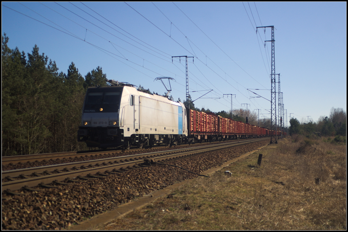 Für LOTOS ist 186 273-9 von Railpool im Einsatz. Am 06.04.2018 fuhr die Lok mit einem langen Holzzug durch die Berliner Wuhlheide.