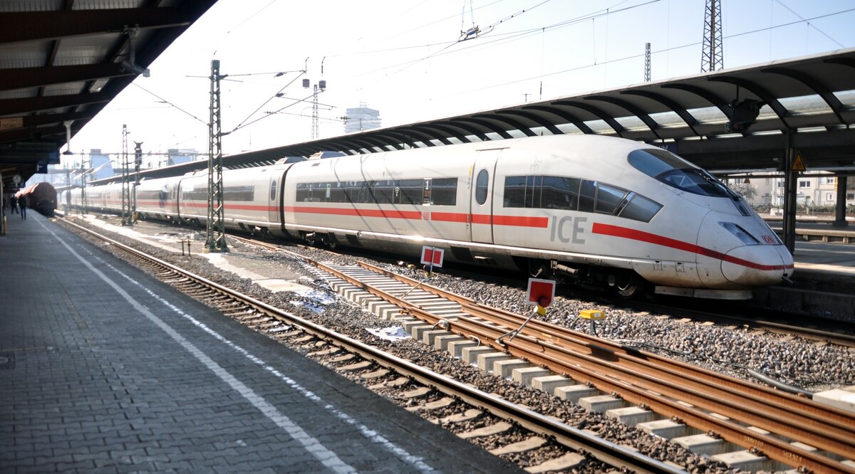 ICE 3 auf dem Weg nach München, hält in Ulm und überholt dabei den auf Gleis 1 stehenden Kalkzug mit 185 001-5 am 09.02.2023. Diese Verkehrsabläufe gibt es, seitdem das Durchgangsgleis zwischen Gleis 1 und 2 entfernt wurde.