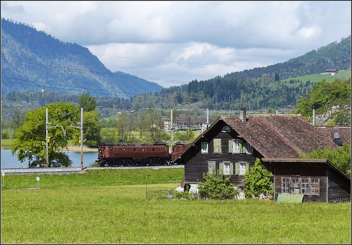 Postkartenidylle am Lauerzer See. So darf es denn auch mal wie eine Postkarte aus den 70er-Jahren aussehen, wenn Be 4/6 12320 den historischen Zug nach Brunnen zieht. Hinter dem Anwesn steckt schon die Grossmutter Ce 6/8<sup>I</sup> 14201 ihre Nase, pardon Köfferli raus. Seewen, Mai 2017.