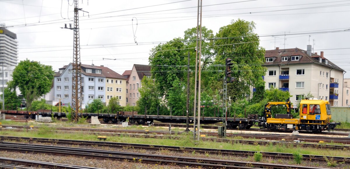 Rottenwagen mit Kranarm D-SPAG 99 80 9610 028-9 und drei 4-achsige Rungenwagen fahren aus dem Baubereich in Ulm aus am 11.05.2023.