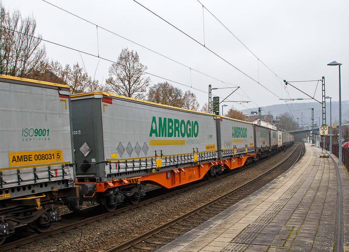 Sechsachsiger Drehgestell-Gelenk-Containertragwageneinheit 90´, 33 85 4961 666-6 CH-WASCO der Gattung Sggmrss 90`der Wascosa AG am 14.01.2022, beladen mit 45` Wechselbrücken der Ambrogio, im Zugverband bei der Durchfahrt im Bf Kirchen (Sieg) an der Siegstrecke (KBS 460) in Richtung Köln.

Diese Gelenkwagen mit sechs Radsätzen sind für den Transport von Großcontainern und Wechselbehältern vorgesehen. Auf den Außenlangträger des Wagens befinden sich für jede vorgesehene Ladeposition feste und klappbare Aufsetzzapfen zum Festlegen der Ladungseinheiten (gemäß UIC- Merkblatt 592-1 und 2) in verschiedenen Kombinationen.

Das aus zwei Wagenhälften bestehende Untergestell ist eine verwindungsweiche, geschweißte Rahmenkonstruktion aus Walz- und Blechprofilen, gebildet aus den Kopfstücken, den Hauptquerträgern und den äußeren Langträgern. In der Wagenmitte befindet sich eine Übersteigmöglichkeit.

TECHNISCHE DATEN:
Spurweite: 1.435 mm
Länge über Puffer: 29.590 mm
Drehzapfenabstand: 2 x 11.995 mm
Achsabstand in den Drehgestellen: 1.800 mm
Drehgestelle: 3 x Y25Lss1-K
Laufraddurchmesser: 920 mm (neu)
Ladelänge: 2 x 13.820 mm
Höhe der Ladeebene über S.O.: 1.155 mm
Eigengewicht: 27.900 kg
Max. Zuladung bei Lastgrenze S: 107,1 t (ab Streckenklasse D)
Max. Zuladung bei Lastgrenze SS: 92,1 t (ab Streckenklasse C)
Max. Geschwindigkeit: 100 km/h (Lastgrenze SS und leer 120 km/h)
Kleinster befahrbarer Gleisbogen: R 75 m 
Bremse: 2 x KE-GP-A 
Bremssohle: Jurid 816M
Feststellbremse: Ja
Verwendungsfähigkeit: TEN GE
