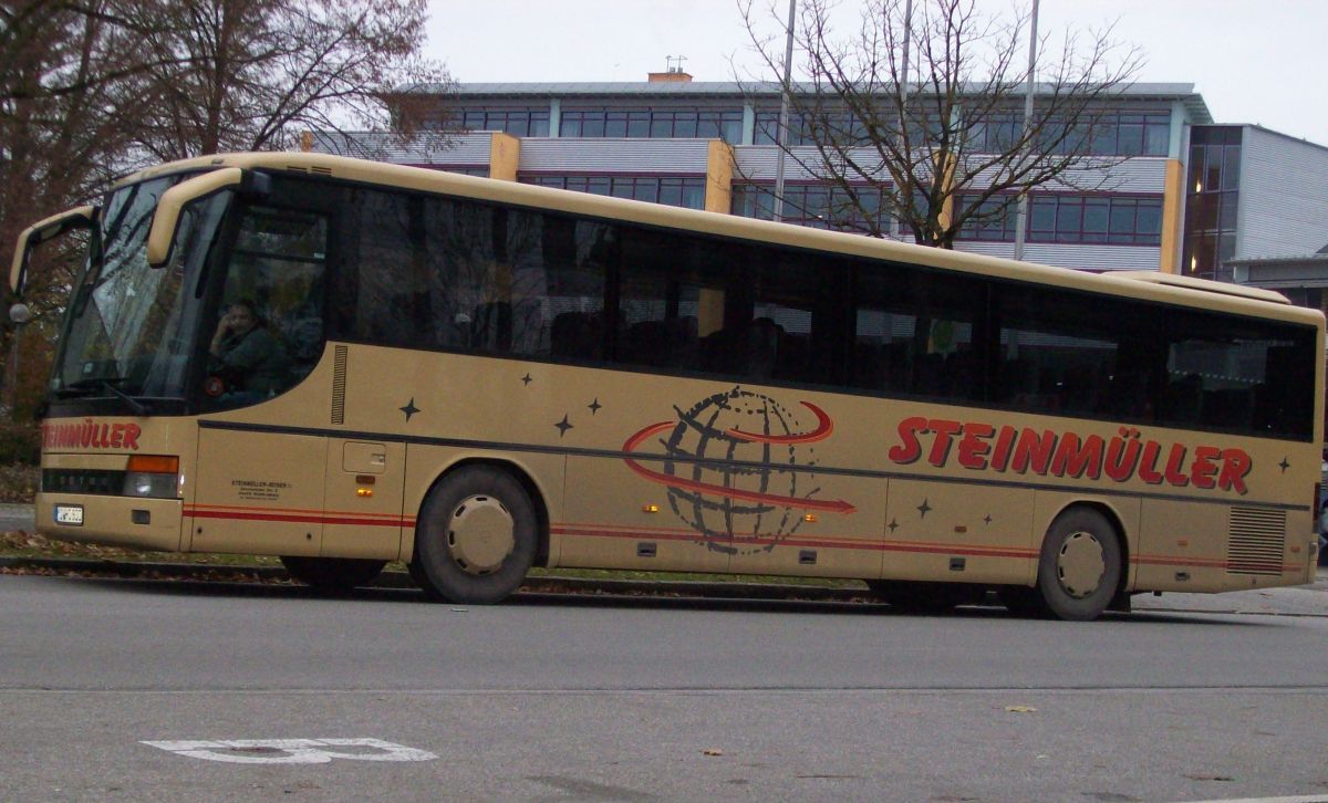 Setra S 315 GT von Steinm�ller Reisen, Waldkraiburg (heute: Hofstetter Reisen, Bad Endorf). Der aus Frankreich stammende Kombibus ist vom Baujahr 1995, verf�gt �ber 57+1 Sitzpl�tze (EC-Schlafbestuhlung, kippbare Sitzbank am Mitteleinstieg) und als Antrieb �ber einen V6 Typ MB OM 441 LA mit 250 kW (340 PS) sowie ein pneumatisches Schaltgetriebe mit acht G�ngen ( Doppel-H-Schaltung ), Typ ZF 8 S-180. Anfang 2014 wurde der Bus an Hogger Reisen aus Freilassing abgegeben.
Die Aufnahme entstand am 12. 11. 2012 in Waldkraiburg, Franz-Liszt-Stra�e (Schulzentrum), wo er zur Abfahrt auf der RBO-Linie 7510 Kurs 003 in Richtung Heldenstein/Haigerloh bereitstand.
