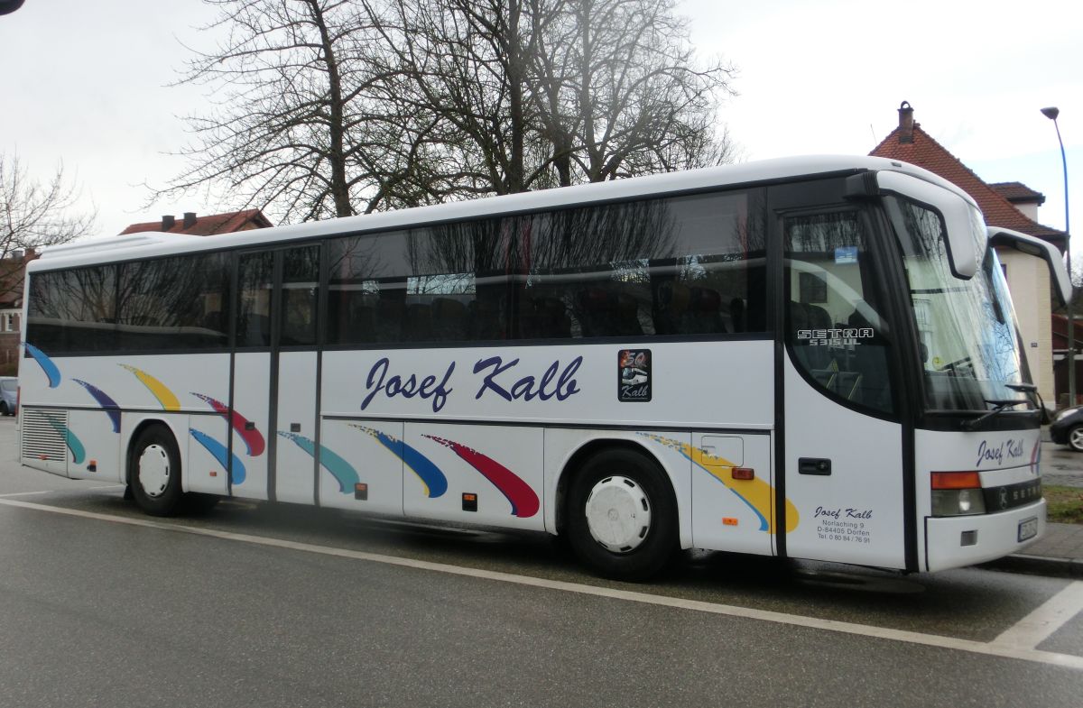 Setra S 315 UL-GT von Josef Kalb aus Norlaching bei Dorfen. Zwar handelt es sich noch um ein Vorfacelift-Exemplar, jedoch schon um eines mit Euro-3-Motor. Der Bus ist Jahrgang 2001/2002 und inzwischen leider schon verkauft.
Zur Ausstattung gehören 51+2 Schlafsessel vom Modell 'Top' mit Lederkopfteil (mit kippbarer Sitzbank am Mitteleinstieg), montiert auf den 330 mm hohen Podesten, ein erhöhter Mittelgang (Innenboden auf dem Niveau der H/GT-Modelle), eine TV-Anlage mit zwei Monitoren sowie Rückfahrwarnsensoren. Der Antriebsstrang setzt sich aus einem Reihensechszylinder Typ MB OM 457 hLA mit 260 kW (354 PS) und einem Sechsgang-Schaltgetriebe Typ MB GO 190-6 zusammen.
Diese Aufnahme entstand am 2. 4. 2015 am Bahnhof in Ampfing, als der Bus auf einem Schienenersatzverkehr auf dem Abschnitt Mühldorf - Ampfing der Bahnstrecke Mühldorf - München zum Einsatz kam.