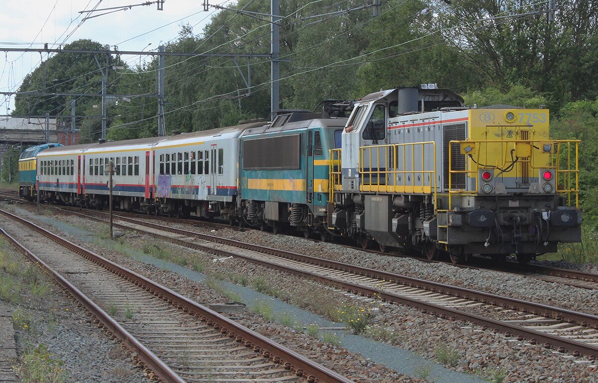 SNCB 7753 schiebt am 17 Augustus 2024 ein Sonderzug durch Saint-Ghislain und wird vom offenbar zugängiger Platz fotografiert. Weil wegen Streckenarbeiten an die Bocq-Strecke das jahrliche Festival du Chemins der Fer du Bocq dort nicht stattfand, wurden die Sonderzüge ins ehemahlige Industrierevier von Saint-Ghislain geführt.