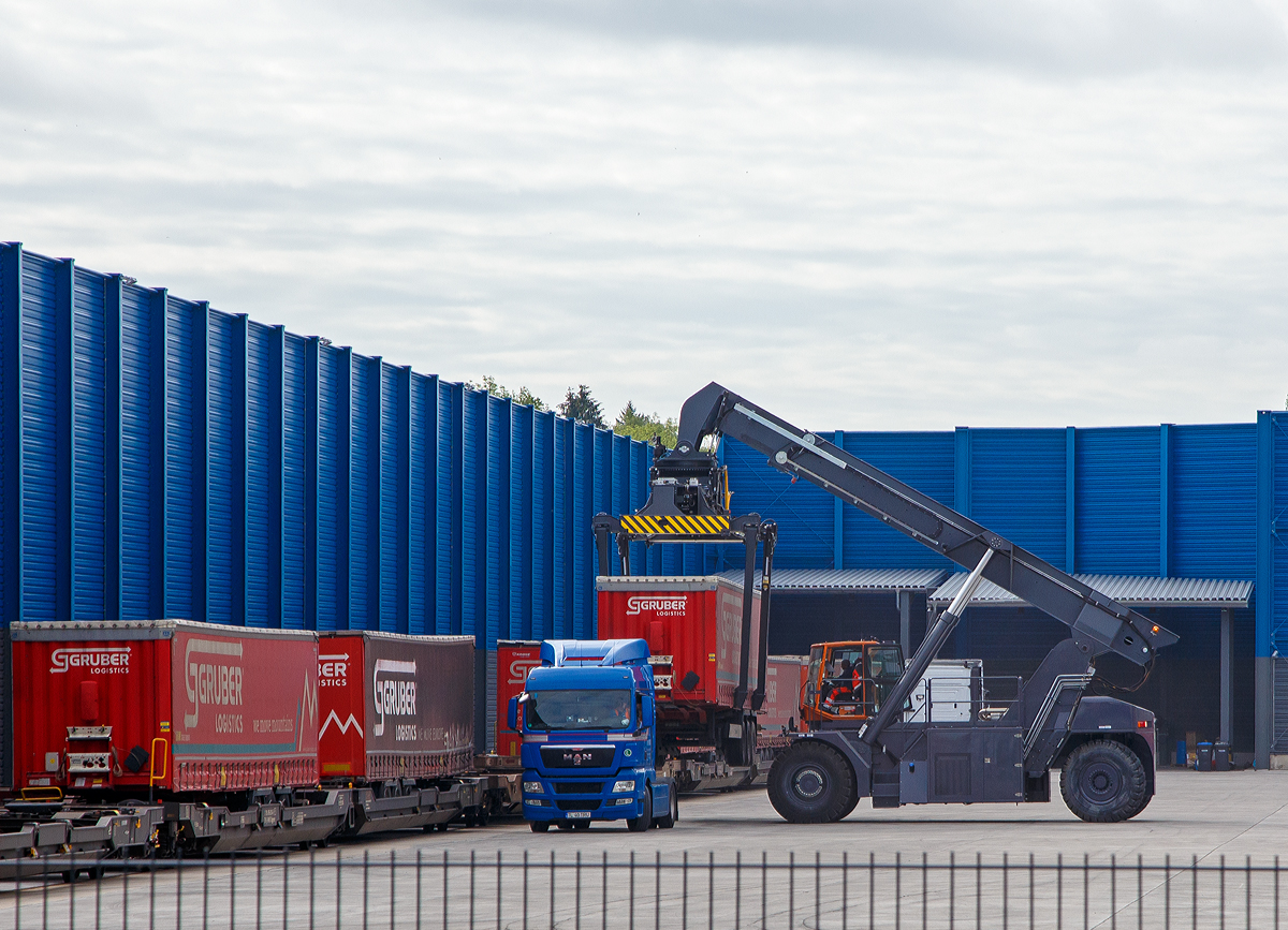 
Südwestfalen Container-Terminal GmbH (SWCT), Kreuztal Ubf, den 31.05.2019:
Die Entladung der Gelenk-Taschenwagen der Gattung Sdggmrs (Typ T3000e).  Die Sattelauflieger (Sattelanhängern) werden nach und nach mittels Reachstacker bzw. Greifstapler aus den Gelenk-Taschenwagen gehoben und sofort an die Sattelzugmaschine angehangen.
