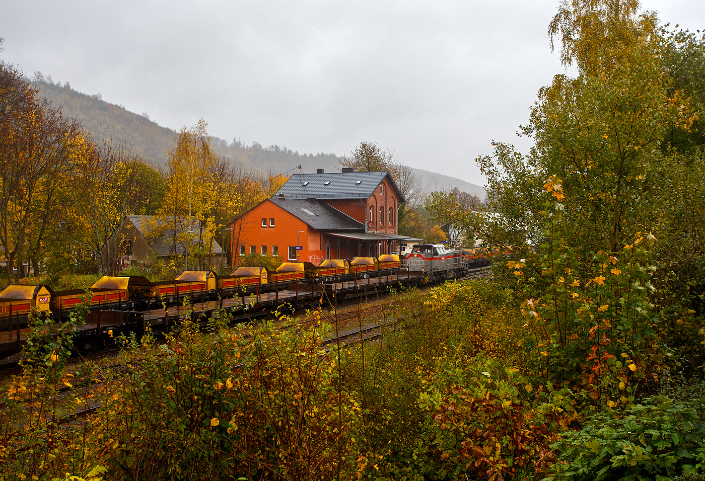 Baustelle Bahnhof Herdorf am 25 Oktober 2025, es schttete ohne Unterlass, dazu noch heftige Windben, aber die Arbeiten zur Erneuerung der Weiche 3 und der Rckbau mit Lckenschluss fr die drei aufeinander folgenden Weichen 22, 23 und 24 (Erneuerung Anschluss von Weiche 26 an Gleis 4) haben begonnen. So musste ich doch dem widrigen Wetter an die Strecke. 

Bei dem Wetter haben die Gleisbauarbeiter mein vollstes Mitgefhl. Da haben es die Lokfhrer und Baggerfahrer durch den Schutz ihrer Kabine schon besser. 

Hier seht u.a. die 271 022-6 „Charlotte“ (92 80 1271 022-6 D-KAF) eine Vossloh/MaK G 1000 BB der KAF Falkenhahn Bau AG. ex MRCE bzw. ex HGK DH 49, mit einigen Flachwagen. Hinten auf Gleis 1 steht sehr langer Schotterzug (ca. 600 m) an dessen Ende die Vossloh G 12 – 4120 001-7 „Karl August“ (92 80 4120 001-7 D-KAF) befindet. 