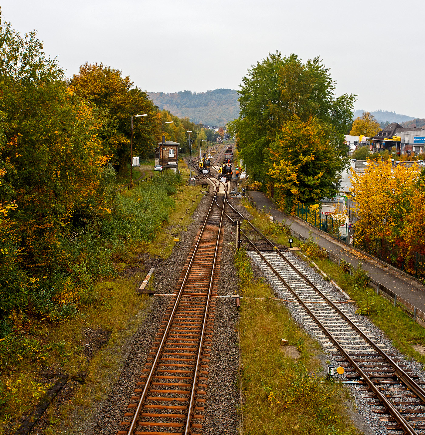 Blick auf den Bahnhof Herdorf und die Baustelle in Blickrichtung Betzdorf am Mittag des 12 Oktober 2025. Die Weichen 25 und 26 sind beide eingebaut, müssen noch eingeschottert werden, zurzeit haben die Gleisbauarbeiter aber ihre wohlverdiente Mittagspause. 

Übrigens hier kann man deutlich die Grenze der Streckenkassen der Bahnstrecke Betzdorf–Herdorf-Haiger „Hellertalbahn“ (KBS 462). Bis kurz hinter der Weiche 27, zum Gleisanschluss des Rangierbahnhofs der KSW (Betriebsstätte Freien Grunder Eisenbahn KSW NE447 / DB-Nr. 9275), ist die Streckenkasse D4 (Achslast 22,5 t / Meterlast 8,0 t/m). Links ab der ersten Stahlschwelle hinter der Weiche hat die Strecke in Richtung Haiger dann die Streckenkasse CE (Achslast 20,0 t / Meterlast 8,0 t/m). Rechs das Gleis ab der Gleissperre ist das Anschlussgleis der KSW (Kreisbahn Siegen-Wittgenstein) und gehört auch der KSW. 

Was ich nicht verstehe das man in Deutschland Bahnstecken wieder, für sehr hohe Kosten, reaktiviert. Was ich auch gut finde, aber hier würde ich mir einen Ausbau auf komplett D4 wünschen. Auch eine Elektrifizierung der Strecke oder gar eine Reaktivierung des zweiten Gleises der 36 Kilometer langen Strecke, könnte ich mir vorstellen, die Strecke war früher ja zweigleisig. Dann müsste der Güterverkehr nicht den Umweg über Siegen machen. 
