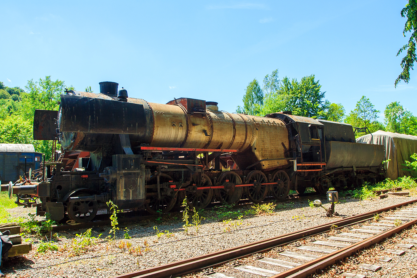 Damals (am 16 Juni 2013) leider einem sehr schlechten Zustand präsentierte sich die bei der AMTF - Association des Musée et Tourisme Ferroviaires a.s.b.l. (Train 1900) in Fond-de-Gras abgestellte CLF 5621 der SSMN - Service des Sites et Monuments Nationaux.

Die Lok wurde 1943 von der Krauss-Maffei AG in München-Allach, als Kriegsdampflokomotive 1 (KDL 1) unter der Fabriknummer 16630 gebaut und als 52 3504 an die DRB (Deutsche Reichsbahn) geliefert. Nach dem 2. Weltkrieg verblieb sie in Österreich und wurde so zur ÖStB 52.3504 (Österreichische Staatseisenbahn) und ab August 1947 zur ÖBB 52.3504 (Österreichische Bundesbahnen). 1978 wurde die Lok durch die Vereinigung GAR - Groupement des Amis du Rail von der ÖBB übernommen. Nach ihrem Verkauf an die GAR wurde die Lok über mehrere Tage von Wien-Nord in das Bahnbetriebswerk Luxembourg überführt. Am 9.September 1978 wurde mit Hilfe der 215 072 die letzte Etappe von Ulm über Lauda und Mainz nach Luxemburg absolviert. Am 16. August 1980 wurde die Lok nach langer Abstellzeit wieder in Betrieb genommen. Nach der betriebsfähigen Aufarbeitung kam die Lok vom 6. September 1980 bis April 1981 vor Museumszügen bei der Chemin de Fer des Trois Vallées in Mariembourg (Belgien) zum Einsatz. Anschließend war die Lok von Mai 1982 bis Oktober 1984 bei der Merzig-Büschfelder Eisenbahn im Saarland im Einsatz. Schlussendlich wurde die Lok im Oktober 1984 nach Luxembourg rücküberführt, da die Revisionsfristen abgelaufen waren und die Lok aus dem Betrieb genommen wurden. Seither ist die Lok im Depot Luxembourg kalt abgestellt. 2004 wurde die Lok an die Service des Sites et Monuments Nationaux abgegeben. Eine Wiederinbetriebnahme der Lok ist auch in absehbarer Zukunft nicht vorgesehen. Von 2012 bis März 2021 stand die Lok im Depot der Vereinigung  Train 1900  in Fond-de-Gras. Am 26.März 2021 wurde die Lok von Fond-de-Gras nach Pétange in die Neubauhalle der SSMN - Service des Sites et Monuments Nationaux überführt. Hier wird sie wohl nun wieder etwas aufgearbeitet.
