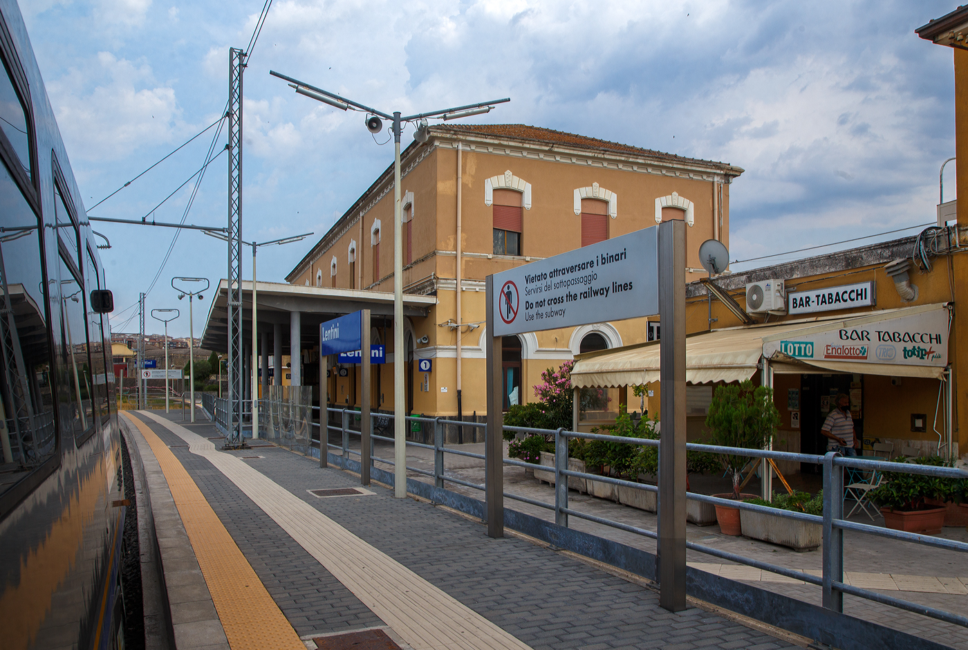 Der Bahnhof Lentini/Sizilien (italienisch Stazione di Lentini/Sicilia) bei km 154,4 an der Bahnstrecke Messina–Syrakus (RFI 152) am 19 Juli 2022.

Der Bahnhof Lentini wurde im Rahmen des Eisenbahnbauprojekts der Gesellschaft Vittorio Emanuele errichtet, welches von der Società per le strade ferrate della Sicilia (Sizilianischen Eisenbahngesellschaft) fortgeführt wurde. Er war Teil des Projekts, die Gegend um Syrakus (Siracusa) per Eisenbahn mit der Stadt und dem Hafen von Catania zu verbinden und landwirtschaftliche Produkte, insbesondere Zitrusfrüchte, aus der Gegend um Lentini und der Ebene von Catania zu den Märkten zu transportieren. Der Bahnhof wurde am nördlichen Stadtrand von Lentini, in der Nähe des Lentini-Sees, errichtet und am 1. Juli 1869 eingeweiht, zeitgleich mit der Eröffnung der Eisenbahnlinie Catania Centrale nach Lentini. Am 19. Januar 1871 wurde er mit der Eröffnung des letzten 57,8 km langen Abschnitts bis zum Bahnhof Syrakus (Siracusa) auch mit Syrakus, im Südosten von Sizilien, verbunden.

Neben den Regionalzüge halten in dem Bahnhof auch Fernverkehrszüge der Gattung Intercity (IC) und Intercity Notte (ICN). 

Ca. 4 km nördlich in Lentini Diramazione zweigt zudem die Bahnstrecke (RFI 154) nach Gela ab.

Merkmale
Der Bahnhof besteht aus einem zweistöckigen Gebäude am südlichen Ende des Gleiskomplexes. Das Bahnhofsgebäude befindet sich westlich der Gleise. Der Bahnhof ist ein Haltepunkt für Personenzüge aller Kategorien.

Der Gleiskomplex umfasst das erste Durchgangsgleis, ein Überholgleis und ein Vorranggleis für den Personenverkehr sowie mehrere Gütergleise. Nur das erste Gleis verfügt über einen Unterstand. Die verschiedenen Güter- und Abstellgleise befinden sich auf der Westseite des Bahnhofs. Früher fuhren viele Güterzüge mit Zitrusfrüchten vom Bahnhof Lentini ab. Seit Ende der 1980er Jahre ist der Verkehr deutlich zurückgegangen.

Am 15. Dezember 2019 weihte der Präsident der Region Sizilien den modernisierten Bahnhof ein. Insbesondere wurde eine Unterführung mit Rampen für Behinderte und neue Bahnsteige errichtet. 

Quellen: Wikipedia (Italien) 
Stand: September 2025
