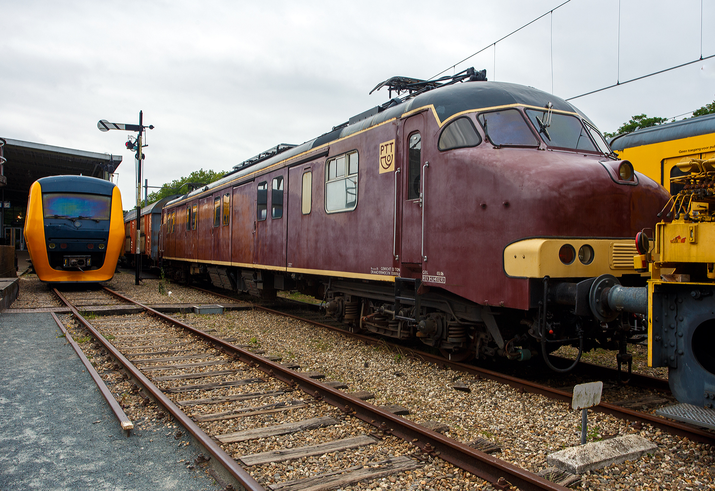Der Posttriebwagen/Motorpost mP 3031 (Plan mP Serie 3000), ein speziell für den Posttransport konzipierter Elektrotriebwagen, am 24 Juni 2025 im Het Spoorwegmuseum (bis 2005 NSM - Nederlands Spoorwegmuseum / Niederländischen Eisenbahnmuseum) in Utrecht im ehemaligen Bahnhof Maliebaan. Ein sehr schönes Eisenbahnmuseum das zum Verweilen einlädt.

Der elektrische Posttriebwagen/Motorpostwagen der Baureihe mP 3001–3035 wurde 1966 von Werkspoor N.V. in Utrecht gebaut und an die PTT (Staatsbedrijf der Posterijen, Telegrafie en Telefonie / niederländische Post) geliefert und bei der NS - Nederlandse Spoorwegen (Niederländischen Staatsbahnen) eingestellt. 

Vorgeschichte:
Ab 1956 wurden 25 Mat '24 Elektotriebwagen -  Blokkendozen  (Kastendose) aus den Jahren 1926–1930, die zuvor im Personenverkehr eingesetzt worden waren, versuchsweise zu Motorpostwagen der Serie mP 9200 umgebaut. Dadurch sollten die durch den Posttransport verursachten Störungen im Personenverkehr reduziert werden. Nach dem erfolgreichen Versuch wurde 1963 die Anschaffung neuer Motorpostwagen beschlossen. In den Jahren 1965 und 1966 trafen 35 ein, die als Baureihe Plan mP Serie 3000 (PTT mP 3001–3035) eingereiht wurden. 

Sie boten eine Grundfläche von 41 m² und eine Ladekapazität von 15 Tonnen. Auf beiden Seiten waren drei große Schiebetüren zum Be- und Entladen der Rollbehälter mit Postsäcken angebracht. Es gab auch einen kleinen Sortierbereich. Die Anhängelast der Motorwagen reichte aus, um 200 Tonnen zu ziehen. So konnten sie vier beladene Postwagen oder acht Güterwagen ziehen. Die Hauptfarbe war Braun, wie die Farbe der Güterwagen. 1975 wurde ein größerer Teil der Front gelb lackiert.

Im Jahr 1978 wurden 60 speziellen Postgüterwagen der Nummern 2422 000–063 der Gattung Hbbkkss angeschafft um den Postverkehr völlig unabhängig vom Personenverkehr abwickeln zu können. Sie waren jedoch nicht braun, sondern rot lackiert. Die gezogenen und stromlinienförmigen Postwagen wurden ausgemustert. Das Museum besitzt auch den P 7920 bzw. den stromlinienförmigen P 8502. Ab 1982 wurden die Motorpostwagen in PTT-Rot lackiert, um besser zu den ebenfalls roten Postwagen zu passen.

Die Motorpostwagen wurden im Auftrag der PTT durch die NS (Niederländische Eisenbahn) gewartet und von Lokführer der NS gefahren.

Technik:
Die Triebwagen sind 26.400 m lang, 2.760 m breit und 3.800 m über den Schienen hoch. Das Gesamtgewicht beträgt 55 Tonnen. Dank der vier Achsen beträgt die Achslast 13,75 Tonnen. Jede Achse ist mit einem Fahrmotor vom Typ Smit-Heemaf ausgestattet. Jeder Motor hat eine Leistung von 138 kW (188 PS). Die Gesamtleistung des Triebwagens beträgt so 552 kW (752 PS). Dies entspricht dem Antriebssystem eines Triebwagens der Baureihe Plan V. Daher verfügen die Triebwagen über eine sehr hohe Beschleunigung. Ein leerer Triebwagen beschleunigt in 55 Sekunden auf 125 km/h. Die höchstzulässige Geschwindigkeit betrug 140 km/h. Die Triebwagen sind mit zwei Westinghouse-Kompressoren mit einer Kapazität von 280 l/min ausgestattet. Auf dem Dach sind zwei Faiveley AM 30-Stromabnehmer mit Doppelschleifstücken montiert. Die Achsfolge ist Bo'Bo'. 

Aufbau:
Der Führerstandaufbau ist nahezu identisch mit dem der Triebwagen der Baureihen V und T. Der einzige Unterschied besteht darin, dass sich neben der rechten Führerstandstür ein zusätzlicher Rangierführerstand befindet. In Führerstand I befindet sich mittig an der Rückwand eine Tür zum Zugführerabteil. In Führerstand II bietet diese Tür Zugang zum großen Ladebereich mit vier Ladetüren auf jeder Seite. Auch das Zugführerabteil ist vom Ladebereich aus zugänglich. Auch eine Toilette ist im Triebwagen vorhanden.

Die Motoren sind in einer Aufhängung montiert. Der Fahrmotor ist einseitig rollengelagert auf der Achse gelagert. Die Motorachse wird von einem Ritzel angetrieben, das mit einem festen Zahnrad auf der Radachse kämmt. Durch die Verwendung von Rollenlagern anstelle von Gleitlagern konnte die Anzahl überhitzter Lagerstellem erheblich reduziert werden. Der Triebwagen ist für eine Geschwindigkeit von 140 km/h ausgelegt. Unter dem Waggon befinden sich zwei Kompressoren. Diese können 280 Liter Luft pro Minute liefern. Diese Luft wird für die elektropneumatischen Bremsen und verschiedene elektropneumatische Geräte verwendet. Zur Stromversorgung des Steuerkreises und der Beleuchtung ist unter dem Waggon ein Heemaf-Motorgenerator installiert. Dieser wandelt die 1.500 Volt Oberleitungsspannung in 100 Volt für den Steuerkreis und 145 Volt für die Beleuchtung um. Der Motorgenerator hat eine Leistung von 5 kW. Die Schaltschränke und Relaiskästen befinden sich unter dem Waggon. An die Motorwagen können maximal drei beladene Postwagen gekuppelt werden. Die Drehgestelle basieren auf denen der Pläne T und V, haben jedoch einen um 250 mm größeren Radstand von 3.000 mm.

Im Gegensatz zum den Mat '64 mit ihren Scharfenberg-Kupplungen, verfügen die mP 3000 über konventionelle Schraubenkupplungen und Puffer, die das Ankuppeln an Postwagen der Baureihen Plan C, Plan E und Plan L sowie an Güterwagen ermöglichten. Bis zu drei mPs konnten in Mehrfachtraktion gefahren werden. Die Postmotorwagen waren zunächst wie die alten Blokkendoos-Motorwagen rotbraun lackiert.

TECHNISCHE DATEN:
Gebaute Anzahl: 35
Nummerierung: mP 3001 bis 3035
Eigentümer/Betreiber: PTT / NS
Hersteller: Werkspoor N.V., Utrecht
Baujahre: 1965/66	
Ausmusterung: 1995 bis 2008
Spurweite: 1.435 mm (Normalspur)
Achsfolge: Bo'Bo' 
Länge über Kupplung: 26.400 mm
Breite: 2.760 mm
Höhe über SO: 3.800 mm
Drehzapfenabstand: 18.350 mm
Achsabstand im Drehgestell: 3.000 mm
Treibraddurchmesser: 950 mm (neu)
Leergewicht: 52 t 
Höchstgeschwindigkeit: 140 km/h (im Plandienst 125 km/h)
Motorentyp: 4 Stück vom Typ Smit-Heemaf TM 671 á 138 kW (188 PS)
Stundenleistung: 552 kW (752 PS)
Dauerleistung: 488 kW / (663 PS)
Stromsystem: 1,5 kV Gleichstrom
Stromabnehmer: 2 Stück Faiveley Typ AM 30
Anzahl der Sitzplätze: 2
Max. Zuladung: 15 t (Post)

Der niederländische Postverkehr:
Gleichzeitig mit dem Ausbau des Autopostnetzes entstand auch das sogenannte Sternnetz. Utrecht diente als Knotenpunkt für alle Post-Züge der elf verschiedenen PTT-Versandstellen. Die Einrichtung dieser Knotenpunkte ermöglichte eine bessere Konzentration des Postverkehrs. Täglich fuhren Postzüge von Amsterdam, Haarlem, Zwolle, Leeuwarden, Groningen, Arnheim, ’s-Hertogenbosch, Den Haag, Roosendaal, Rotterdam und Sittard nach Utrecht, um dort in einen Postzug mit neuem Ziel umgeladen zu werden oder Rollcontainer mit Post in Säcken oder Paketen auszutauschen. Ziel war es, möglichst wenige Container umzuladen. Zusätzlich zum Sternnetz gab es das sogenannte Randstad-Netz zwischen Rotterdam, Den Haag, Haarlem und Amsterdam. Pro Tag fanden insgesamt fünf Umläufe statt, einer morgens, einer nachmittags, zwei abends und der letzte nachts. Auch samstags und sonntags nachts fanden Umläufe statt. Lkw´s lieferten die Post zu und von den Versandzentren. Auch Deventer und Eindhoven verfügten über ein kleines Versandzentrum, das jedoch optional betrieben wurde.

Die meisten Poststationen befanden sich in der Nähe der Hauptbahnhöfe der genannten Städte und waren mit einem Sortierzentrum und manchmal sogar einem Postamt ausgestattet.

Einstellung des Postverkehrs per Bahn:
1992 wurde der erste PTT Motorpost Triebwagen an die Niederländische Eisenbahn (NS) übergeben. Der mP 3032 wurde zu einem ATB-Messwagen umgebaut und ersetzte den Messwagen „Jules“, der aus Mat '24 umgebaut worden war. Der mP 3032 erhielt den Spitznamen „mP Jules“. Später wurde das Messunternehmen aus der NS ausgegliedert und der Messwagen an Eurailscout übergeben.

1995 erwarb die NS erneut mehrere Triebwagen von der Niederländischen Post (PTT). Diese dienten dem Transport von Material und Ausrüstung zwischen den verschiedenen Werkstätten. Ab Mai 1997 wurde der gesamte Postverkehr per Bahn in den Niederlanden eingestellt. Die letzten überzähligen Triebwagen wurden daraufhin an NS Cargo verkauft. Auch diese ehemaligen Triebwagen wurden hauptsächlich für den Transport zwischen den Werkstätten und einigen anderen leichten Güterzügen eingesetzt. Geplant war außerdem der Transport von Blumen zwischen Groningen und Hoofddorp. Diese Pläne wurden nie umgesetzt, und der Transport zwischen den Werkstätten über ein eigens dafür konzipiertes Sternnetz wurde bald eingestellt.

Danach wurden die meisten ehemaligen Triebwagen außer Betrieb genommen und abgebrochen. Verwertbare Teile wurden anschließend für die Züge von Mat '64 eingelagert. Zwei Triebwagen (mP 3027 und mP 3030) blieben als Laufwagen für verschiedene leichte Verbindungen und für Übungsfahrten im Einsatz.

Vier Triebwagen (mP 3024, mP 3029, mP 3033 und mP 3034) wurden zu Messwagen für ERTMS umgebaut. Nach diesen von Railion und ProRail in Auftrag gegebenen Messungen wurden mP 3024 und mP 3029 an Eurailscout übergeben. Der mP 3024 wurde zum Messwagen „mP Jim“ umgebaut, und mP 3029 diente als Ersatzteilspender. Die Triebwagen 3027, 3030, 3033 und 3034 wurden 2009 verschrottet. Der mP 3029 wurde Ende 2019 von der Stichting 2454 CREW übernommen.

Museale Erhaltung:
Der Triebwagen (mP 3031) wurde der Sammlung des Niederländischen Eisenbahnmuseums in Utrecht hinzugefügt. Er wurde in der Farbe Rotbraun neu lackiert, die er bei seiner Auslieferung hatte. Der Postwagen Hbbkkss 242 2 043 ist ebenfalls Teil der Sammlung.

Die Stadskanaal Rail Foundation in Stadskanaal besaß den Postwagen Hbbkkss 242 2 019. Dieser Wagen wurde 2023 an die 2454 CREW Foundation übergeben. Nachdem mP 3029 Ende 2019 von der 2454 CREW Foundation erworben wurde, wurde er im ehemaligen Lokschuppen in Roosendaal restauriert. Er wurde in der rot-gelben PTT-Lackierung der 1990er Jahre, mit Beschriftung und ohne NS-Logos, wieder fahrbereit gemacht und am 16. Februar 2021 an das SSN-Gelände geliefert. Er kann besichtigt werden.

Quellen: Somda RailWiki.nl, Het Spoorwegmuseum, nmld.nl, Anschriften, Wikipedia (Niederlande) 
Stand/Überarbeitung: September 2025
