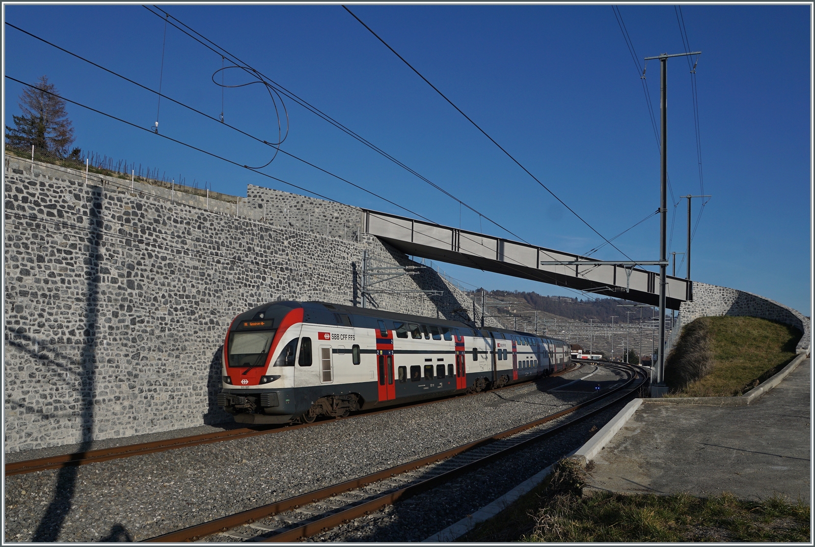 Der SBB RABe 511 027  von Annemasse nach St-Maurice bei der Einfahrt in Cully; verwirrende die falsche Anschrift  Genève Flughafen . 

16. Feb. 2023