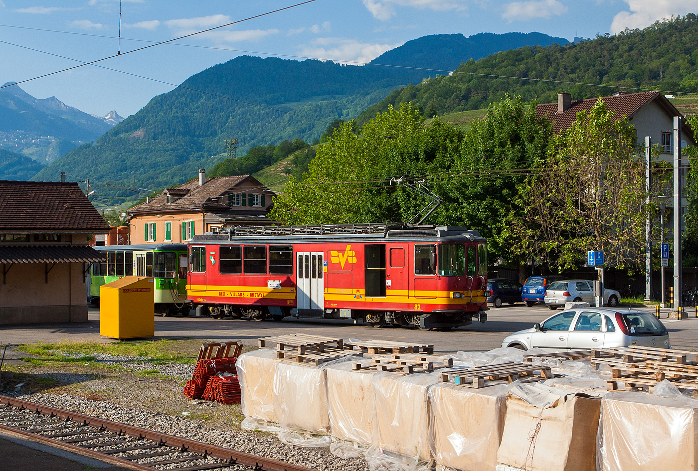 Der tpc BVB BDeh 4/4 82 „Ollon“, ein elektrischer Personentriebwagen mit Gepckabteil fr den gemischtem Adhsions- und Zahnradbetrieb, steht am 28 Mai 2012, noch in originaler Farbgebung, mit einem Pendelzug am Bahnhofsvorplatz Bex. Damals gingen die Gleise vom Bahnhof nach links Richtung Gterschuppen. Die Wagen vom Pendelzug (Steuerwagen und der Zwischenwagen B 62) hatten schon die neue grne TPC-Farbgebung. 

Bild aus dem Zug heraus.