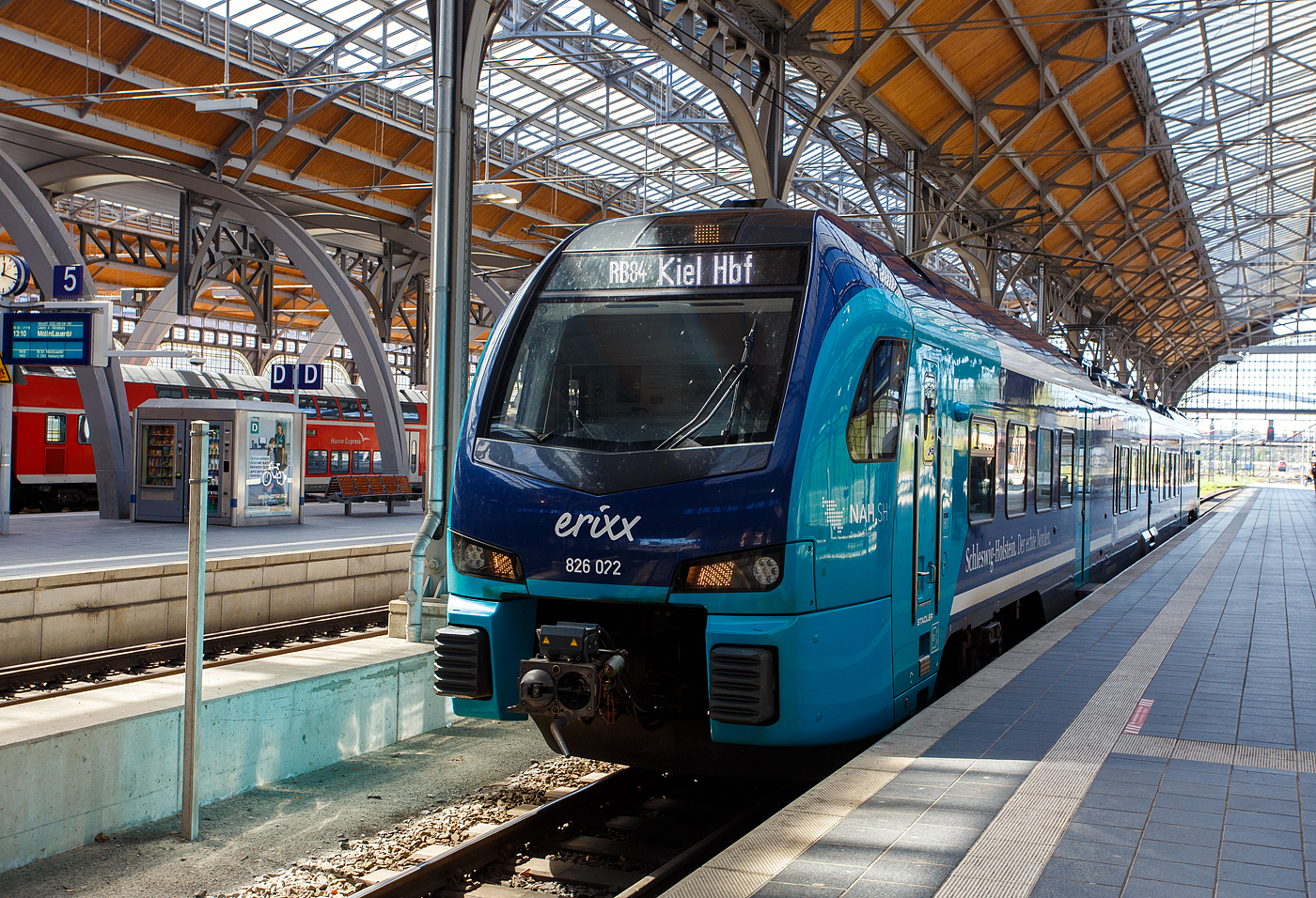 Der zweiteilige erixx Stadler FLIRT� Akku 526 022 / 826 022 (94 80 2526 022-5 D-SRSDE / 94 80 2826 022-2 D-SRSDE) im NAH.SH-Design (Schleswig-Holstein), als RB 84 L�beck Hbf nach Kiel Hbf, am 21 April 2026 im Hauptbahnhof L�beck. 

Der FLIRT wurde 2023 von Stadler Deutschland GmbH in Berlin- Pankow gebaut. Eigent�mer ist die Paribus Rail Portfolio III GmbH & Co. KG in Hamburg und vermietete diese an die erixx Holstein GmbH in L�beck, die die f�r den Nahverkehrsverbund Schleswig-Holstein (NAH.SH) einsetzt. Eingestellt diese FLIRT� Akku �ber die Stadler Rail Service Deutschland GmbH (D-SRSDE).

FLIRT Akku spart allein in Schleswig-Holstein j�hrlich 10 Millionen Liter Diesel und rund 26.000 Tonnen CO₂.

Mitte 2019 gewann Stadler eine Ausschreibung des Nahverkehrsverbunds Schleswig-Holstein �ber 55 FLIRT Akku f�r 600 Millionen Euro, einer der gr��ten Auftr�ge f�r Batteriez�ge in Deutschland. Seit Oktober 2023 ist diese weltweit erste batterieelektrische Zugflotte im regelm��igen Linienbetrieb unterwegs. Dank dieser Akkuz�ge hat das Bundesland den zweith�chsten Elektrifizierungsanteil unter den Fl�chenl�ndern Deutschlands, 68 Prozent aller Strecken werden nun elektrisch befahren. Der �kologische Vorteil: Rund 10,4 Millionen Zug-Kilometer werden „entdieselt“. 

Bald werden die FLIRT Akku-Triebz�ge in weiteren deutschen Bundesl�ndern wie auch in �sterreich, D�nemark, Litauen und den USA einen emissionsfreien Betrieb auf nicht elektrifizierten Strecken erm�glichen.

Der FLIRT Akku ist die batteriebetriebene Ausf�hrung der FLIRT-Typenreihe. Der Nahverkehrsverbund Schleswig-Holstein (NAH.SH) hat im Juli 2019 im Rahmen einer Innovationspartnerschaft 55 zweiteilige FLIRT Akku bestellt. Die batteriebetriebenen Triebz�ge verkehren seit Oktober 2023 auf den Strecken der Netze Nord und Ost.

Einsatzgebiete sind: Kiel-L�beck-L�neburg, Bad Oldesloe-Neum�nster, Neum�nster-Heide-B�sum, Kiel-Rendsburg-J�beck-Husum, Husum-Bad St.Peter Ording, Kiel-Eckenf�rde-Flensburg, Kiel-Sch�nberger Strand

Ausgelegt sind die FLIRT Akku Triebz�ge f�r nicht- oder nur teilelektrifizierte Strecken und so vielseitig einsetzbar. Das Laden der Batterien ist w�hrend der Fahrt unter Oberleitung sowie an elektrifizierten Endhaltepunkten m�glich. Zus�tzlich wird die Bremsenergie in den Batterien gespeichert. Damit kann das Fahrzeug effizient und energiesparend eingesetzt werden. Die Erbringung aller Instandhaltungs- und Serviceleistungen �ber 30 Jahre durch den Hersteller garantiert eine zuverl�ssige Verf�gbarkeit. Das mit Lithium-Ionen-Akkus ausgestattete Fahrzeug f�hrt in Schleswig-Holstein als zweiteilige Zugkomposition. Der voll klimatisierte FLIRT Akku f�r die NAH.SH verf�gt �ber mit Fahrgast-WLAN ausgestattete, helle Fahrgastr�ume sowie gro�z�gig gestaltete Mehrzweckbereiche und bietet 216 Fahrg�sten Platz, darunter 123 auf Sitzpl�tzen.

Technische Merkmale
Technik
Automatische Mittelpufferkupplungen
Leichtbauweise aus Aluminium
Luftgefederte Fahrwerke sorgen f�r die erforderliche Laufruhe
Oberleitungsbetrieb mit 15 kV sowie oberleitungsfreier Betrieb mit Lithium-Ionen-Traktionsbatterie
Schnellladung der Lithium-Ionen-Traktionsbatterie mittels 15 kV Oberleitung

Komfort
Heller, freundlicher Fahrgastraum
Klimatisierter Fahrgastraum und Fahrerraum
Gro�z�gig gestaltetes Multifunktionsabteil an allen Einstiegsbereichen
2 Einstiegst�ren pro Seite
Spalt�berbr�ckungen an allen T�ren
Fahrradstellpl�tze/Rollstuhlbereiche
Modernes Fahrgastinformationssystem
Universal WC nach TSI PRM
WLAN 

Personal
Ergonomisch gestalteter Fahrerarbeitsplatz

Spezifikationen
Betriebliche Reichweite im Akkubetrieb bis zu 150 km
H�chstgeschwindigkeit max. 160 km/h
Ladezeit unter Oberleitung: 15 Minuten
Sitzpl�tze: 123

Ersatzteillieferung und technische Instandhaltung �ber 30 Jahre durch Hersteller

FLIRT Akku: F�hrt da weiter, wo die Oberleitung endet
Moderne Z�ge m�ssen auf Strecken ohne Oberleitung nicht mit Diesel fahren. Leistungsstarke Batterien k�nnen Z�ge �ber Teilstrecken frei von CO₂-Aussto� und zuverl�ssig mit Strom versorgen. Die batterie-elektrischen Triebz�ge (BEMU) von Stadler sind ausgelegt f�r nicht- oder nur teilelektrifizierte Strecken und damit vielseitig einsetzbar.Auf Streckenabschnitten mit Oberleitung fahren die Z�ge klassisch elektrisch mit gehobenem Stromabnehmer und laden die Batterien. Gleichzeitig wird Bremsenergie zur Aufladung genutzt. Wo die Oberleitung endet, setzen sie ihre Fahrt im Batteriemodus fort. 

Mit dem FLIRT Akku, der batterieelektrischen Antriebsvariante des Bestsellers FLIRT, hat Stadler bereits 2017 den weltweit ersten f�r den Fahrgasteinsatz zugelassenen Batteriezug gebaut.

Das Fahrzeugkonzept beruht in gro�en Teilen auf den vielfach erprobten elektrischen Triebz�gen FLIRT f�r den Betrieb unter Oberleitung. Der FLIRT Akku ist einst�ckig in Leichtbauweise aus Aluminium gefertigt und in zwei- bis vierteiliger Zugkomposition realisierbar. In Serie l�sst sich der FLIRT Akku ebenso wie der FLIRT flexibel und individuell auf die jeweiligen Bed�rfnisse von Kunden und Streckennetz anpassen. Eine Mehrfachtraktion mit rein elektrischen ein- und doppelst�ckigen Fahrzeugen ist ebenfalls m�glich.

Die einzelnen Triebz�ge bestehen aus den zwei betrieblich nicht trennbaren Wagen z.B.:
Wagen A - 94 80 2826 022-2 D-SRSDE, 2. Klasse, Mehrzweckbereich
Wagen B - 94 80 2526 022-5 D-SRSDE, 1./2. Klasse, Rollstuhlpl�tze, barrierefreies WC;

TECHNISCHE DATEN:
Anzahl f�r NAH.SH: 55
Inbetriebsetzung Oktober 2023
Spurweite: 1.435 mm (Normalspur)
Achsanordnung: Bo´2´2´
L�nge �ber Kupplung: 45.700 mm
Fahrzeugbreite: 2.820 mm
Fahrzeugh�he: 4.275 mm
Achsabstand im Drehgestell: 2.700 mm
Trieb- und Laufraddurchmesser: 870 mm (neu)
Leergewicht: 96 t
H�chstgeschwindigkeit: 160 km/h
Dauerleistung am Rad: 1.000 kW (2 x 500 kW)
Traktionsantrieb von TSA: Motor TMF 59-39-4 und Getriebe GMH 2-43-595A
Speisespannung: 15 kV / 16,7 Hz
Stromversorgung: Stromabnehmer auf dem A-Wagen f�r 15 kV, 16,7 Hz AC aus der Oberleitung, 1 Batteriesystem im A-Wagen und 3 Batteriesysteme im B-Wagen
Batteriereichweite: 80 km laut Hersteller (bei Versuchsfahrten mehr als doppelt so weit)
Sitzpl�tze: 105 + 18 Klappsitze, davon 8 in der 1. Klasse
Stehpl�tze (4 Pers./m�): 123 (93 bei besetzten Klappsitzen)
Rollstuhlpl�tze: 2 im B-Wagen
Fahrradstellpl�tze: Im A-Wagen
Fu�bodenh�he: Niederflur 780 mm, Hochflur 1.145 mm
Einstiegsbreite: 1.300 mm
Einstiegsh�he: 780 mm

Quellen: Stadler Rail
