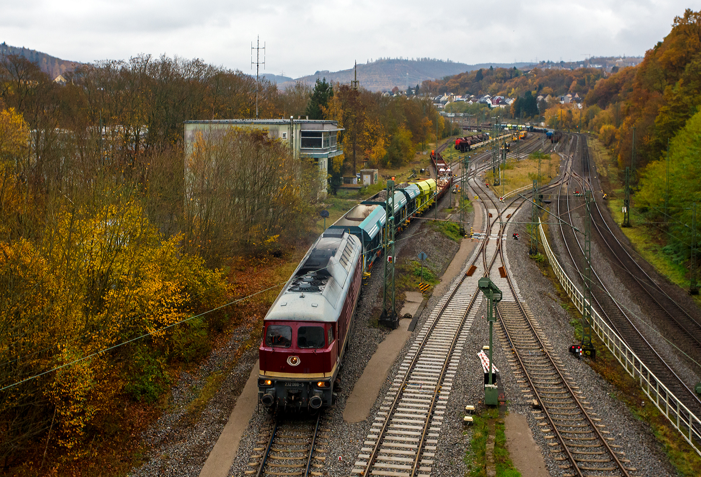 Die „Ludmilla“ in der DR-Farbgebung „bordeauxrot“ 232 088-5 (92 80 1232 088-5 D-SLRS) der SRS - Salzland Rail Service GmbH (Bernburg/Saale) rangiert am 09 November 2025 im Rbf Betzdorf/Sieg einige Schotter- und Res-Wagen. Rechts die zweigleisige Siegstrecke (Köln – Siegen / KBS 460), hinten im Rbf wurde Gleise erneuert und z.Z. wird eins gestopft. Links das Stellwerk Betzdorf Fahrdienstleiter Bf.

Die ex DR V 300 wurde 1974 von LTS (Luhanskyj Teplowosobudiwnyj Sawod auch bekannt als Lokomotivfabrik Lugansk (ehemals Woroschilowgrad)) unter der Fabriknummer 0304 gebaut und als 132 088-6 an die Deutsche Reichsbahn (DR) geliefert.  Zum 01.01.1992 erfolgte die Umzeichnung in DR 232 088-5 und zum 01.01.1994 dann in DB 232 088-5. Die Ausmusterung bei der DB erfolgte zum 30.08.1998. Im August 2002 ging sie an die WAB - Westfälische Almetalbahn GmbH in Altenbeken (als Nr. 30), bis sie im Januar 2004 an die EfW-Verkehrsgesellschaft mbH in Frechen ging. Im Februar 2018 wurde sie dann an die Salzland Rail Service GmbH in Bernburg (Saale) verkauft.

Die Diesellokomotiven der DR Baureihe 130 (DB 230), 131 (DB 231), 132 (DB 232, 233, 234, 241 und 754) und 142 (DB 242) wurden ab 1970 aus der damaligen Sowjetunion in die DDR importiert und bei der Deutschen Reichsbahn für den Personen- und Güterverkehr in Dienst gestellt. Die Baumuster wurden noch als V 300 auf der Leipziger Messe vorgestellt.

Von der Baureihenfamilie wurden zwischen 1970 und 1982 insgesamt 873 Stück in Dienst gestellt. Nach 1990 kam die unter Eisenbahnern ungebräuchliche Bezeichnung „Ludmilla“ auf.

Die Baureihe 132 war universell einsetzbar, sowohl im hochwertigen Schnellverkehr als auch im schweren Güterzugdienst. Nebenstrecken mit weniger als 20 t Achslast konnte die BR 132 nicht befahren.

Die Leistung wird von einem direkteinspritzenden 16-Zylinder-Viertakt-Dieselmotor vom Typ Kolomna 5D49 bereitgestellt. Der Motor liefert mit Turbolader und Ladeluftkühler 2.230 kW (3.000 PS). Der Dieselmotor treibt außer der Licht- und Erregermaschine vor allem einen Drehstromhauptgenerator und einen Drehstromheizgenerator an.

Die Kraftübertragung erfolgt elektrisch. Der Traktionsstrom wird über eine Sechs-Wege-Gleichrichtung von 240 Dioden in Gleichstrom gewandelt. Die Leistungsregelung erfolgt über die Dieselmotordrehzahl und einen Thyristorfeldregler der Erregermaschine.

TECHNISCHE DATEN der BR 232:
Hersteller: 	Lokomotivfabrik Woroschilowgrad (heute Luhansk)
Spurweite: 	1.435 mm (Normalspur)
Achsformel: Co’Co’
Länge über Puffer: 20.820 mm
Breite des Lokkastens: 2.950 mm
Höhe über Schienenoberkannte: 4.590 über SOK
Drehzapfenabstand: 11.980 mm
Achsstand im Drehgestell: 2 x 1.850 mm (3.700 mm)
Treibraddurchmesser: 	1.050 mm (neu) / 952 mm (abgefahren)
Dienstgewicht: 124 t
Radsatzfahrmasse:  20,4 t 
Motorbauart: direkteinspritzenden V-16-Zylinder-Viertakt-Dieselmotor mit Abgasturbolader und Ladeluftkühlung, 4 Ventile pro Zylinder, mit Zylindergruppenabschaltung
Motorentyp: Kolomna 5 D 49 /16 Tsch N 26/26
Motorhubraum: 220,9 l
Ladeluftdruck: 1,3 bar
Einspritzbeginndruck: 320 bar
Max. Verbrennungsdruck: 115 bar
Motorleistung: 2.230 kW (3.000 PS)
Leistungsübertragung: elektrisch
Anfahrzugkraft: 294 kN
Dauerzugkraft: 194 kN
Höchstgeschwindigkeit: 120 km/h
Tankinhalt: max. 6.000 l
