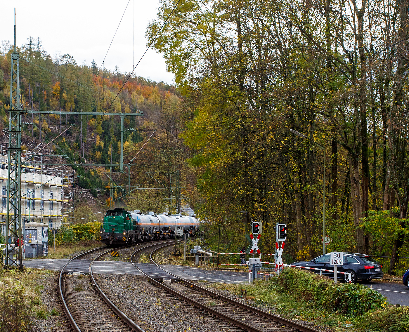 Die dieselelektrische Vossloh DE 12 / 4125 006-1 (92 80 4125 006-1 D-ISL) / Lok 11 der InfraServ Logistics GmbH (Frankfurt/M-Höchst) fährt am 29 Oktober 2025 mit einem Kesselwagenzug durch Kirchen (Sieg) in Richtung Siegen, vermutlich mit dem Ziel Frankfurt am Main-Höchst. Die Wagen waren laut Gefahrguttafelen (265/1017) mit Chor beladen. 

Die DE 12 wurde 2020 von Vossloh in Kiel unter der Fabriknummer 5402431 gebaut und an die InfraServ Logistics gefiefert.

Die InfraServ Logistics GmbH ist eine Tochtergesellschaft der Infraserv Höchst, diese ist Standortbetreiber des Industriepark Höchst in Frankfurt am Main sowie weiterer Standorte und ist eines der vielen Nachfolge-Unternehmen der aufgespaltenen Hoechst AG. Die InfraServ Logistics führt den werk sinternen Verkehr innerhalb des Industrieparks Höchst, aber auch den Güterverkehr auf dem Schienennetz der Deutschen Bahn im regionalen Bereich (Rhein-Main, Rhein-Necker und Rhein-Ruhr) durch. 

