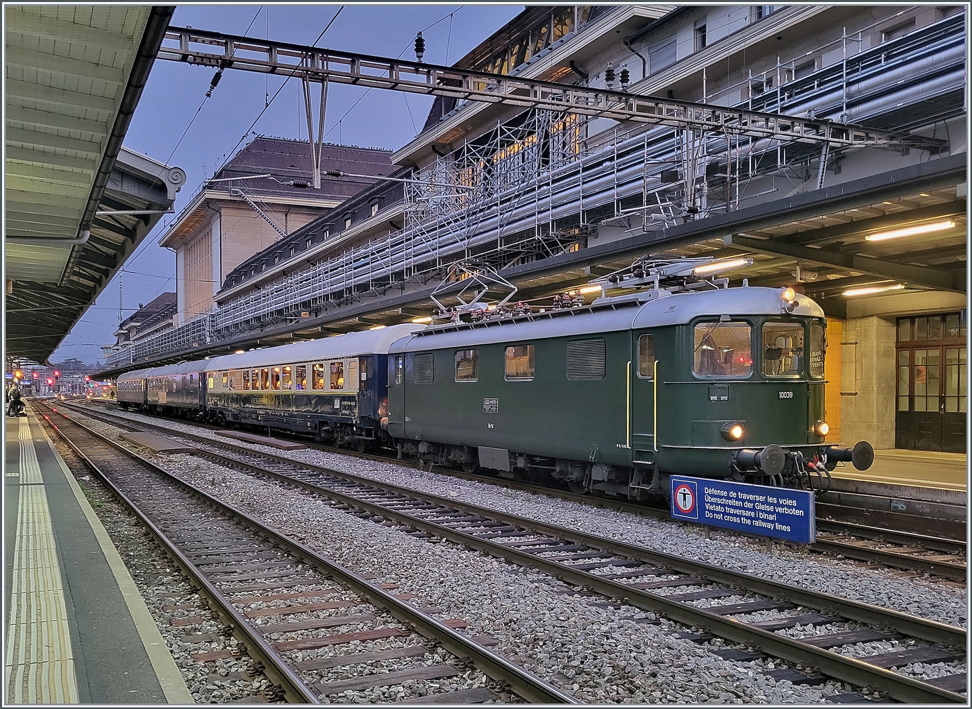 Die Re 4/4 I 10039 stellt den Extrazug 31131 in Lausanne bereit. Der Zug verkehrt für eine Reisegruppe nach Zürich Enge (mit Halt in Palézieux). Der Zug besteht aus dem  Le Salon Bleu  61 85 80-90 200-6 CH-IRSI, dem 56 80 89-80 010-2 WGm D-IRSI und dem Am 56 80 10-40 360-4 D-IRSI. Da der TEE Rheingold Genève - Amsterdam am Schluss seiner Einsatzzeit vor vielen Jahren aus einem DB Speisewagen, einem DB Abteilwagen und einen DB Großraumwagen bestand und auch von einer Re 4/4 I gezogen wurde, weckt der heutige Zug doch Erinnerungen an den TEE 6 / 7, der am 23. Mai 1982 zum letzten Mal ab Genève fuhr, (und sich dann noch gut zwei Jahre auf dem Abschnitt Basel - Amsterdam hielt). Leider die Re 4/4 I 10039 etwas ungeschickt vor dem Schild  Überschreiten der Geleise verboten, und leider waren diese Lichtverhältnisse nichts für meine kleine Knipse, so dass ich hier ausnahmsweise ein Handy-Bild zeige. 11. Dezember 2024