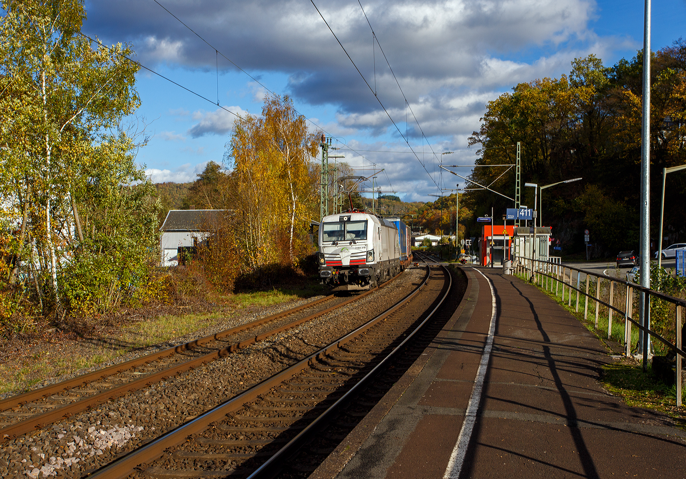 Die recht neue weiße TXL 7193 309 „Connected to Nature“ (91 80 7193 318-1 D-TXL) der TXL - TX Logistik AG (Troisdorf) fährt am 30 Oktober 2025 mit einem KLV-Zug durch Scheuerfeld/Sieg in Richtung Köln. Als Schlussläufer war am Zugschluss zudem die kalte, an die HSL Logistik GmbH vermietete, AKIEM 186 383-6.

Nochmals einen lieben Gruß an den netten Lokführer zurück.

Die SIEMENS Vectron MS (X4E) wurde 2024 von Siemens Mobility in München-Allach unter der Fabriknummer 24282 gebaut und am 24.01.2025 an die TXL ausgeliefert. Die mit 6.400 kW konzipierte Mehrsystemlok ist in der Variante A22-11i ausgeführt und hat so die und hat so die Zulassungen und entspr. Länderpakete für Deutschland, Österreich, Schweiz, Italien und die Niederlande (D / A / CH / I / NL).

Über TX Logistik AG
TX Logistik wurde 1999 als privates Eisenbahnverkehrsunternehmen gegründet und bietet mit Verbindungen in elf Ländern ein leistungsfähiges europäisches Netzwerk. Das Unternehmen verfügt über Tochtergesellschaften in der Schweiz, Österreich, Dänemark und Schweden sowie eine lokale Präsenz in Italien. In den Geschäftsbereichen Intermodal und Rail Freight entwickelt TX Logistik umfassende Schienenlösungen für kontinentale und maritime Verkehre sowie maßgeschneiderte Konzepte für konventionelle Fracht. Mit 650 Mitarbeitern und 8,6 Milliarden gefahrenen Tonnenkilometern erwirtschaftete das Unternehmen 2021 einen Jahresumsatz von 253 Millionen Euro. Seit Januar 2017 gehört TX Logistik zu 100 Prozent der Mercitalia Logistics S.p.A., einer Tochtergesellschaft der FS - Ferrovie dello Stato Italiane. Mittlerweile gehört das Unternehmen mit zu den Größten für den Schienengüterverkehr in Europa.

Das Unternehmen bietet den ganzen Umfang an Schienengüterverkehr, inklusive Containertransport und kombiniertem Verkehr an. Wichtigste Transportstrecken sind von den Häfen Hamburg, Bremerhaven, Rotterdam und Antwerpen nach Süddeutschland, Schweiz, Österreich und Italien.

TX Logistik setzt nun auf eigene Vectron Loks:
Anfang Oktober 2024 hat die TX Logistik AG ersten drei von 40 modernen Vectron-Lokomotiven des Herstellers Siemens Mobility aufs Gleis gesetzt, die das zur Mercitalia Logistics (FS Italiane Group) gehörende Schienenlogistikunternehmen im Mai 2023 bestellt hatte. Die Erweiterung der Fahrzeugflotte ist für TX Logistik eine wichtige Voraussetzung, um im intermodalen und grenzüberschreitenden Schienengüterverkehr weiter zu wachsen. Die neuen Lokomotiven werden vor allem auf dem Brenner- und dem Schweiz-Korridor eingesetzt, den strategisch wichtigen Nord-Süd-Achsen in Europa.

Beide Korridore sind stark frequentiert und stellen hohe Anforderungen an die eingesetzten Lokomotiven – von der Zugkraft über die Stabilität bis hin zur grenzüberschreitenden Systemkompatibilität. TX Logistik hat dazu die Maschinen mit verschiedenen Länderpaketen bestellt. 20 Vectron erhalten das Länderpaket für den Betrieb in Deutschland, Österreich, Schweiz, Italien und den Niederlanden (D-A-CH-I-NL) und sollen bis Anfang 2025 übergeben werden. Die Auslieferung der 20 Lokomotiven mit der Ausstattung für den deutsch-österreichisch-italienischen Korridor (D-A-I) soll bis zum Jahresende 2025 erfolgen.

Die Entscheidung für den Kauf der Vectron-Lokomotiven unterstreicht zugleich das Bestreben von TX Logistik, Schienengüterverkehre als umweltfreundliche und effiziente Alternative zum Straßentransport weiter voranzutreiben. Um dies zu unterstreichen und gleichzeitig für den Einstieg in den intermodalen Transport zu werben, hat die erste der drei Vectrons, die im Zughotel in Braunschweig übergeben wurden, eine spezielle Lok-Beklebung mit dem Schriftzug „Start now (Nature). Driven by Green Passion“ erhalten.

Die neuen Loks bieten mit ihrer Flexibilität und Leistungsfähigkeit ideale technische Voraussetzungen, um den steigenden Anforderungen des europäischen Güterverkehrs gerecht zu werden. Mit der modernen Vectron-Flotte, so TX Logistik, sei man mittelfristig nun in der Lage, die Kapazitäten auf dem Brenner- und dem Schweiz-Korridor deutlich zu erhöhen sowie die Effizienz und Zuverlässigkeit im Schienengüterverkehr weiter zu verbessern.
