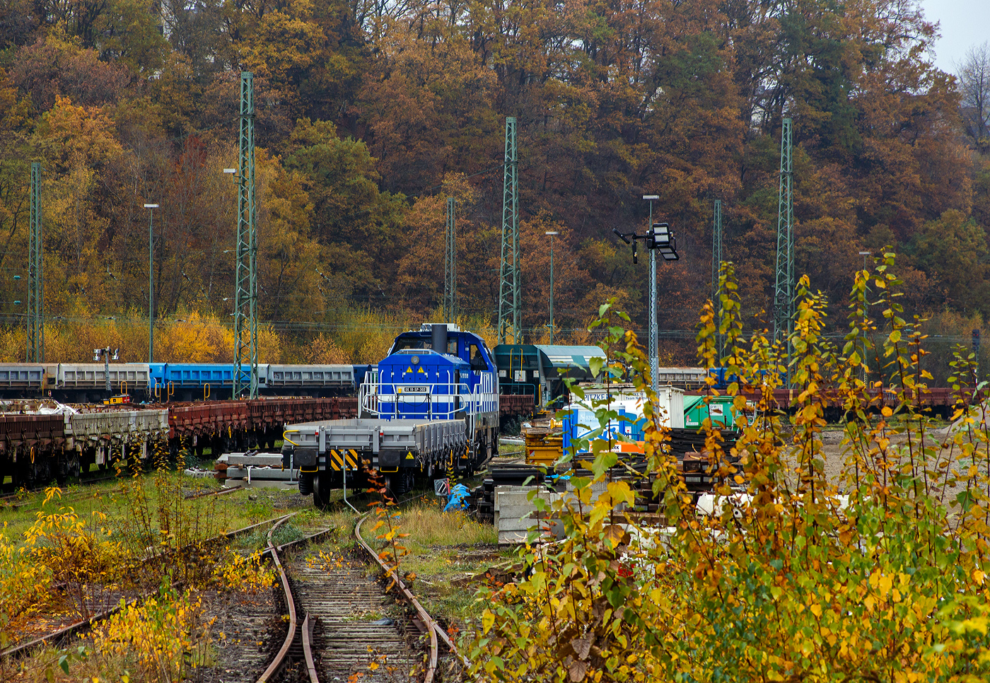Die sehr neue SPITZKE DE18-SP-302 / 4185 302-1 (92 80 4185 302-1 D-SLG) eine dieselelektrische Vossloh DE 18 der SPITZKE SE steht am 08 November 2025 hinter einem Res-Wagen im Rbf Betzdorf/Sieg. 

Die DE18 wurde 2025 von der Vossloh Rolling Stock GmbH in Kiel unter der Fabriknummer 5502655 gebaut und am 14.08.2025 an die SPITZKE SE, Großbeeren ausgeliefert (Tag der Überführung).

Die Diesellokomotive der Baureihe DE 18 ist insbesondere für den schweren Rangier- und Streckenbetrieb mit hoher Zugkraft geeignet. Sie gilt als aktuell leistungsstärkste Mittelführerhauslokomotive auf dem europäischen Markt. Die DE 18 ist für den Rangierbetrieb mit einer Funkfernsteuerung ausgerüstet und ist für bis zu drei Loks mehrfachtraktionsfähig. Durch Energiesparmodus und Start-Stopp-System reduziert sie Schadstoffausstoß und spart Treibstoff ein, zudem besitzt sie einen Rußpartikelfilter. Zusätzlich lässt sich der Kraftstoffverbrauch durch ein effizientes Motormanagement und einer Begrenzung der Motorleistung, wenn nicht die Maximalleistung benötigt wird, reduzieren. Der 1.800 kW starke MTU Dieselmotor wird durch ein Batteriepaket ergänzt, das einen bis zu einstündigen emissionsfreien Rangierbetrieb gewährleistet und Fahrten durch Null-Emissions-Bereiche etwa in Tunneln, Werkhallen oder Bahnhöfen, ermöglicht.

Die Lok hat eine Anfahrzugkraft von 300 kN und eine Dauerzugkraft von 230 kN bei 24.2 km/h. Höchstgeschwindigkeit beträgt 120 km/h, die kleinste Dauerfahrgeschwindigkeit 3 km/h,
