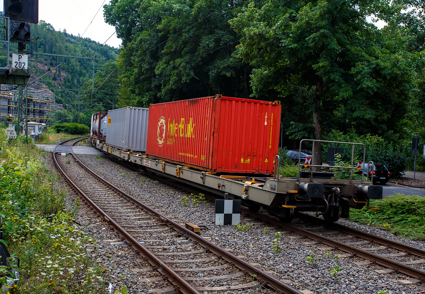Eher ein Exot unter den Taschenwagen, der niedriggelegte achsachsige Doppelwagen Mega I, 33 85 459 6 036-5 CH-HUPAC, der Gattung Saadggns, der HUPAC Intermodal SA (Chiasso), am 01 August 2025 im Zugverband bei einer Zugdurchfahrt im Bahnhof Kirchen/Sieg, hier beladen mit zwei 30`-Container. Die Wageneinheit ist über eine sogenannte Kurzkupplung realisiert. So ist es einer 2x4-achsigen Wageneinheit, also vier Drehgestellen (acht Achsen) pro Wageneinheit.

Diese Wagen wurden in einer Serie von 45 Stück 1994 von der Ferriere Cattaneo SA in Giubiasco (Tessin/CH). Leider sind im Netz keine Datenblätter vorhanden, so kann ich den Wagen nur nach den Anschriften und eigener Sichtung beschreiben.

Diese Güterwagen sind zum Transport von kranmanipulierbaren Sattelaufliegern und genormten Wechselbehältern / Containern an allen europäischen Eisenbahnstrecken mit Normalspurweite bestimmt, auch bekannt als intermodaler Verkehr. Durch die niedrig gelegte Ladefläche können C 70-400 kodifizierte Jumbo-Wechselbehälter bis Norditalien und High-Cube-Container bis Süditalien auf der Gotthardstrecke transportiert werden.

TECHNISCHE DATEN:
Spurweite: 1.435 mm (Normalspur)
Länge über Puffer: 35.570 mm
Drehzapfenabstände: 13.300 mm /4.940 mm / 13.300 mm
Achsabstand in den Drehgestellen: 1.800 mm
Laufraddurchmesser: 840 mm (neu)
Ladelänge: 2 x 15.850 mm (ca. 2 x 52`)
Höhe der Ladeebene für Container/WB über SOK: 940 mm
Höhe der Tasche (für Sattelanhänger) über SOK: 270 mm
Eigengewicht: 33.000 kg
Max. Zuladung: 92,0 t (ab Streckenklasse A)
Max. Gewicht eines Sattelanhängers (je Wageneinheit): 38,5 t
Höchstgeschwindigkeit: 100 km/h (beladen) / 120 km/h (leer)
Bremse: O-GP-A (K) – 2 x 46 t
Bremssohle: Jurid 838 (Komposit-Bremssohlen)
Feststellbremse: Ja, jeweils an den mittleren Drehgestellen
Kleinster befahrbarer Gleisbogen: R 80 m
Verwendungsfähigkeit: RIV (Regolamento Internazionale Veicoli)

Die Bedeutung der Gattungs- und Kennbuchstaben (hier Saadggns):
S - Drehgestell-Flachwagen in Sonderbauart
aa - mit acht oder mehr Radsätzen
d - für den Transport von Straßenfahrzeugen eingerichtet
gg - für den Transport von Containern über 60 Fuß eingerichtet
n - mit sechs oder mehr Radsätzen höchste Lastgrenze über 75 
s - Höchstgeschwindigkeit (beladen) bis zu 100 km/h
