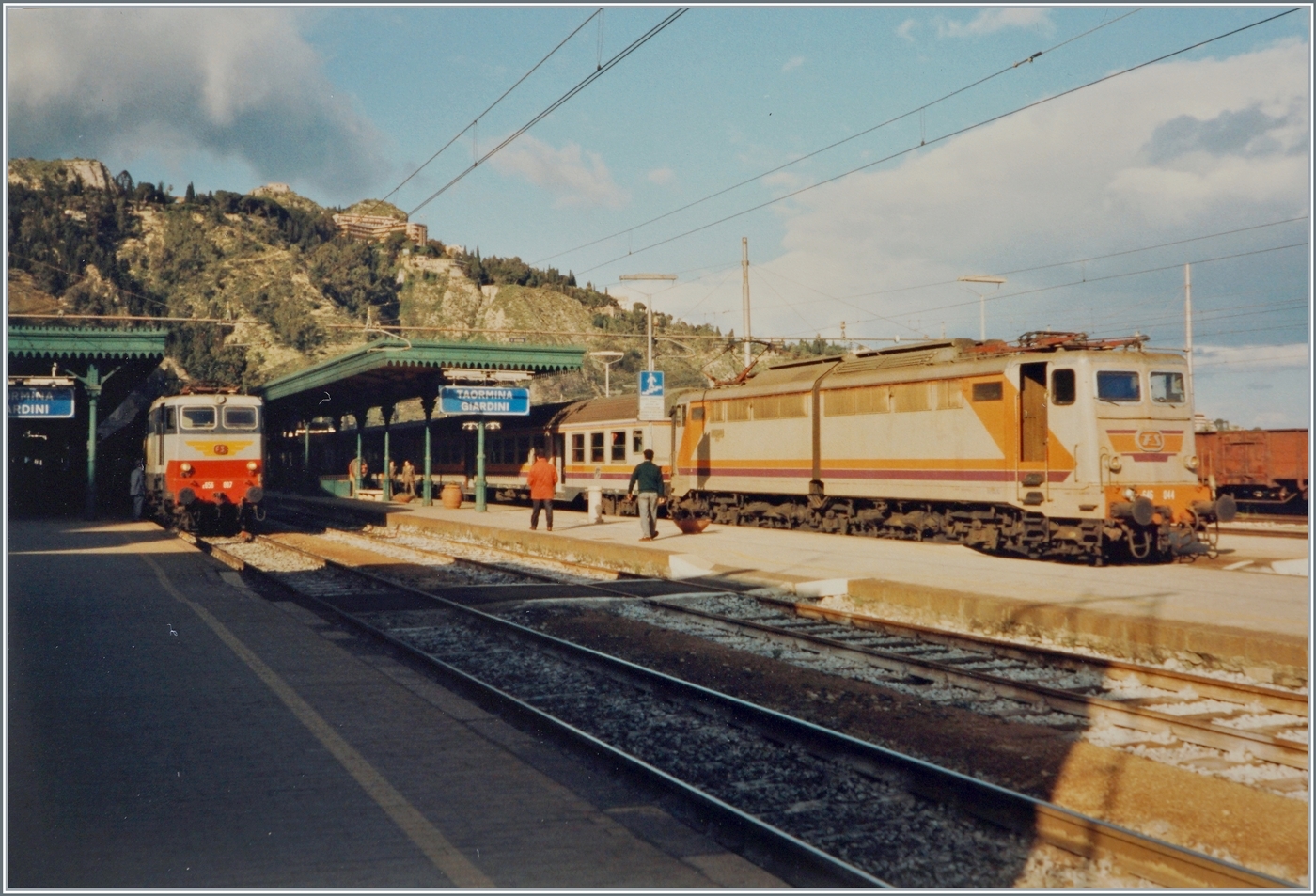 Ein Blick auf den Bahnhof von Taormina-Giardini. Da ich nicht über Aufzeichnungen zu diesem Bild verfüge, interpretiere ich ide Szene folgendermassen: Auf Gleis 3 wartet die FS 646 044 mit ihrem Regionalzug die Überholung des IC aus Roma nach Catania (oder Siracusa) ab. Die FS E 656 097 ist mit ihrem IC  wie zu sehen bereits eingetroffen.

Analogbild vom April 1994