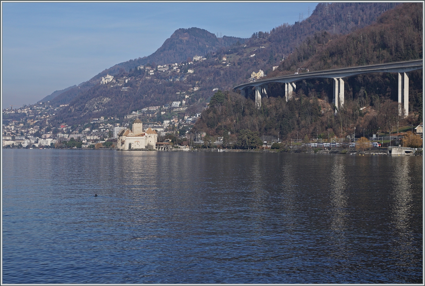 Ein Blick über den See bei Villeneuve zum Château de Chillon und etwas versteckt erkennt man einen SBB RABe 512 auf seiner Fahrt in Richtung Lausanne.

1. Jan. 2026